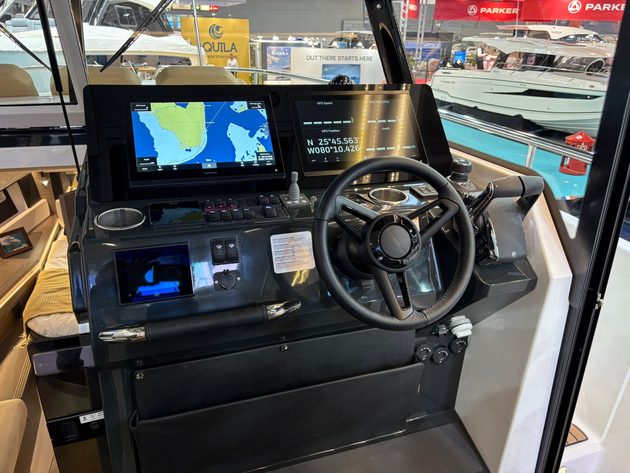 Widok na stanowisko sternika jachtu Wellcraft 38 Explorer z kierownicą, dwoma dużymi ekranami nawigacyjnymi i joystickiem.