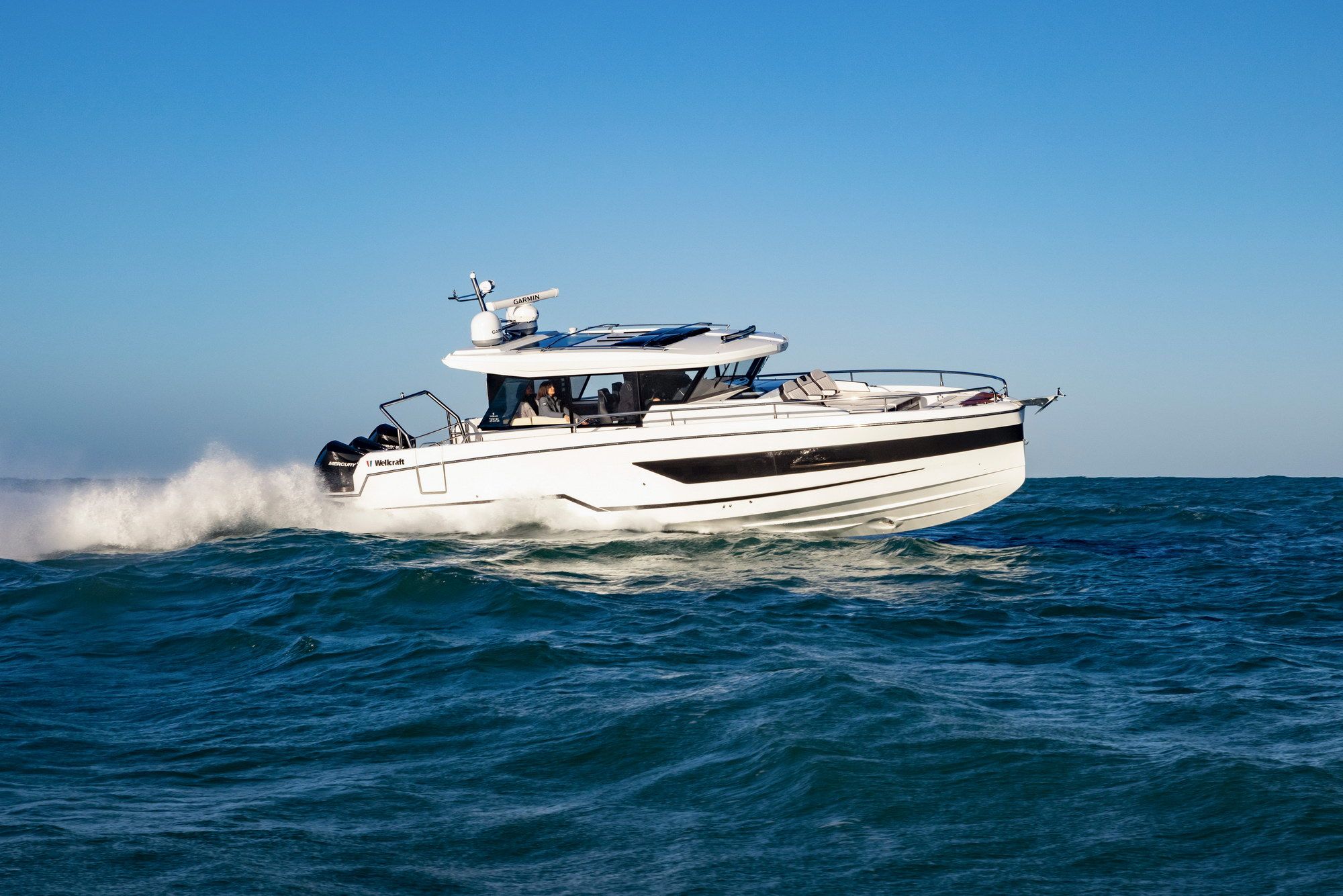 Die weiße Wellcraft 38 Explorer in Fahrt auf offener See, mit drei Mercury-Außenbordmotoren.