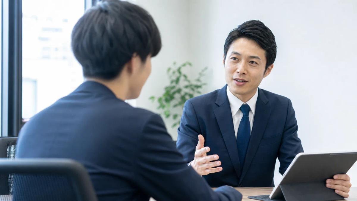 先輩社員が若手社員に対人ロープレの助言をする様子