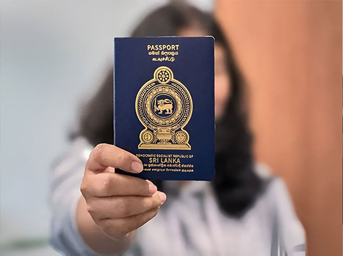 A student holding a Sri Lankan passport with UK student visa