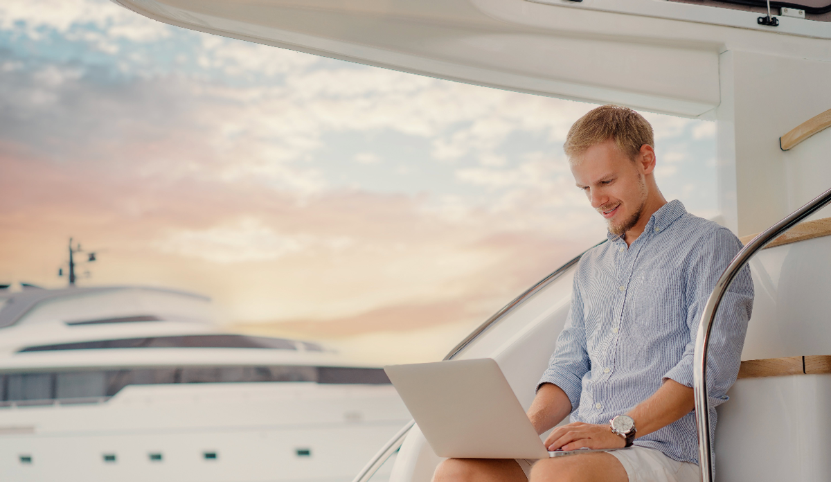 yacht crewmember using laptop on board a yacht