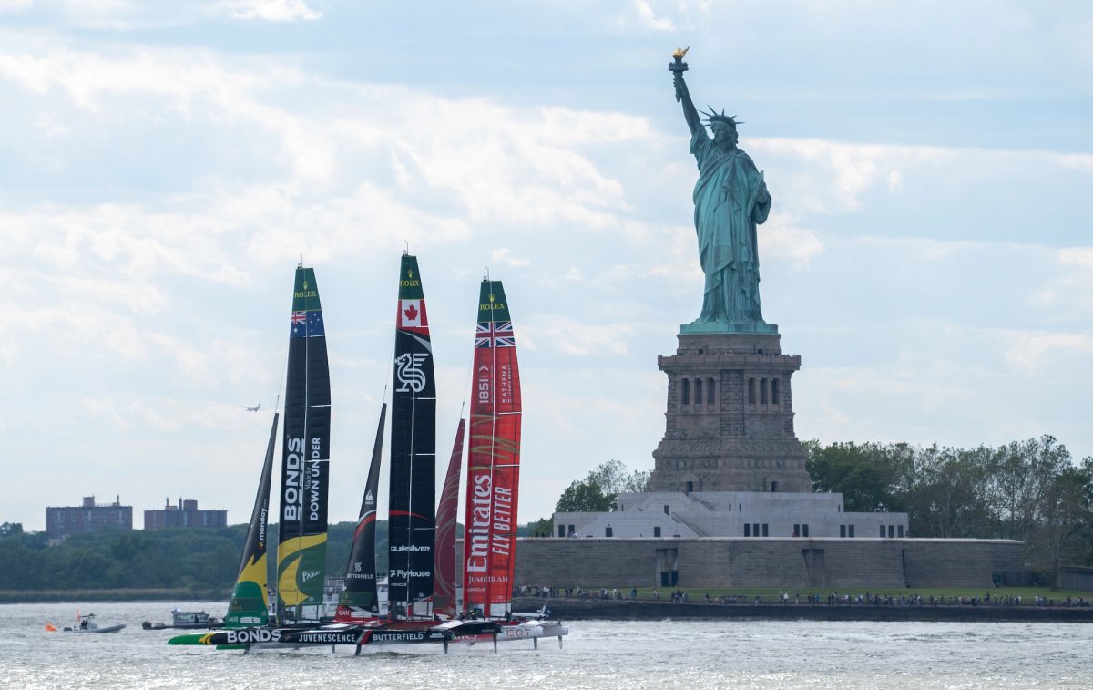 BONDS Flying Roos SailGP Team driven by Tom Slingsby leads NORTHSTAR SailGP Team driven by Giles Scott and Emirates Great Britain SailGP Team driven by Dylan Fletcher past the Statue of Liberty, on Race Day 2 of the Mubadala New York Sail Grand Prix in New York, USA.