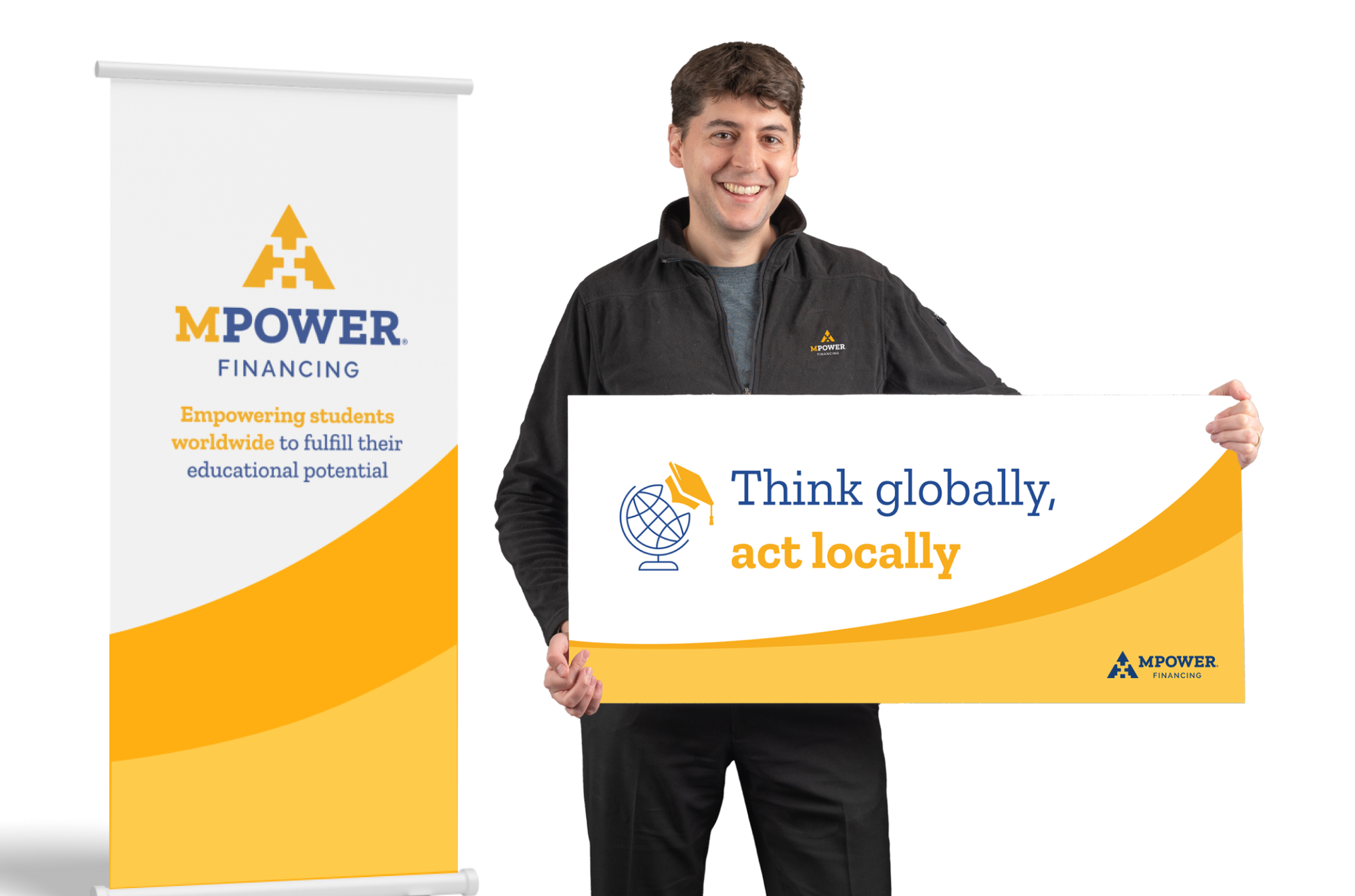 The old brand in the room: a roll-up banner reading “Empowering students worldwide to fulfill their educational potential”, and a man holding a yellow-curved board that says “Think globally, act locally”.