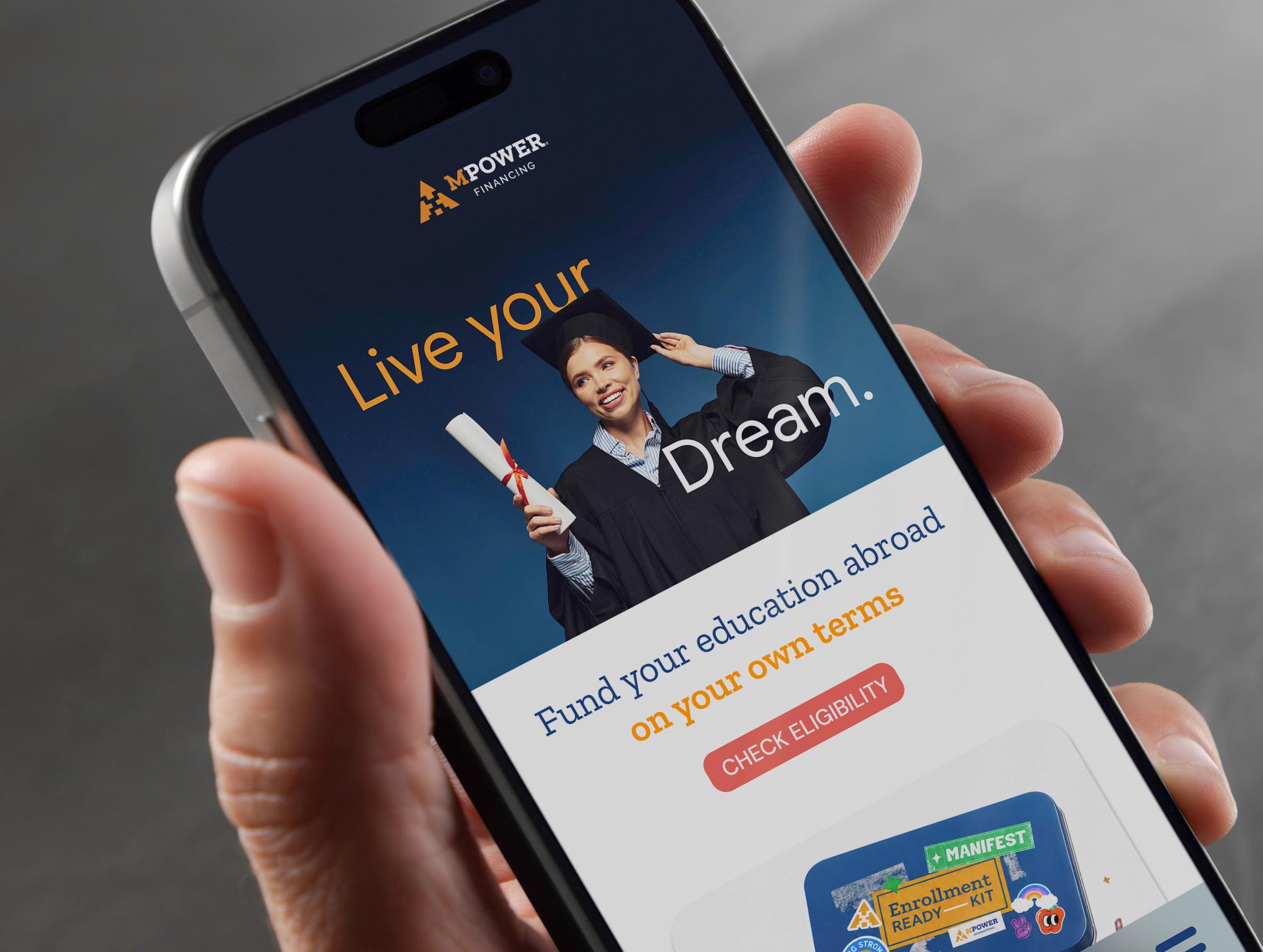 The rebuilt site on a phone held in one hand: “Live your Dream.” over a graduate, and “Fund your education abroad on your own terms” beneath it.