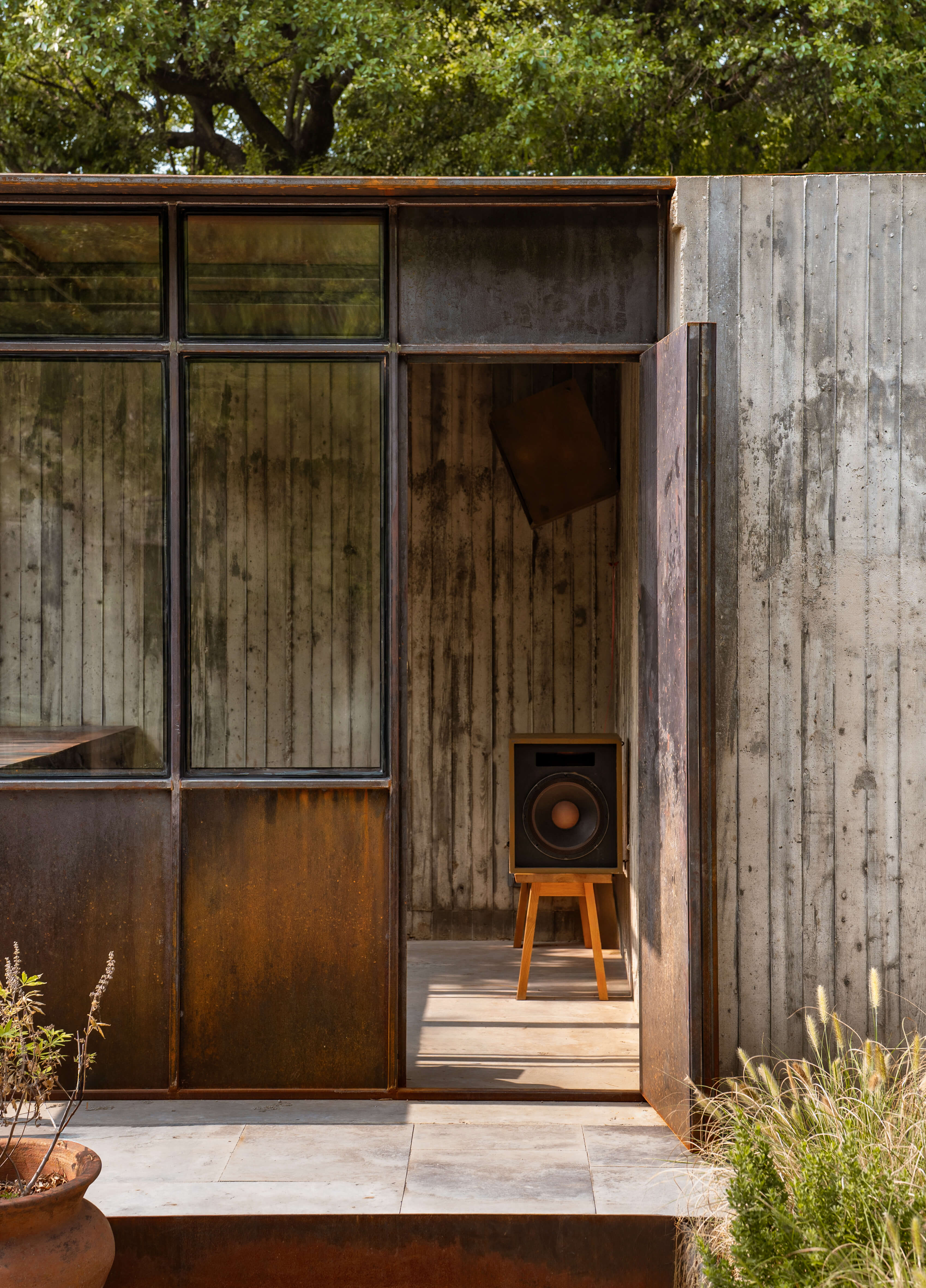Weathered wood and corten steel exterior wall of the Dallas Grand pool house
