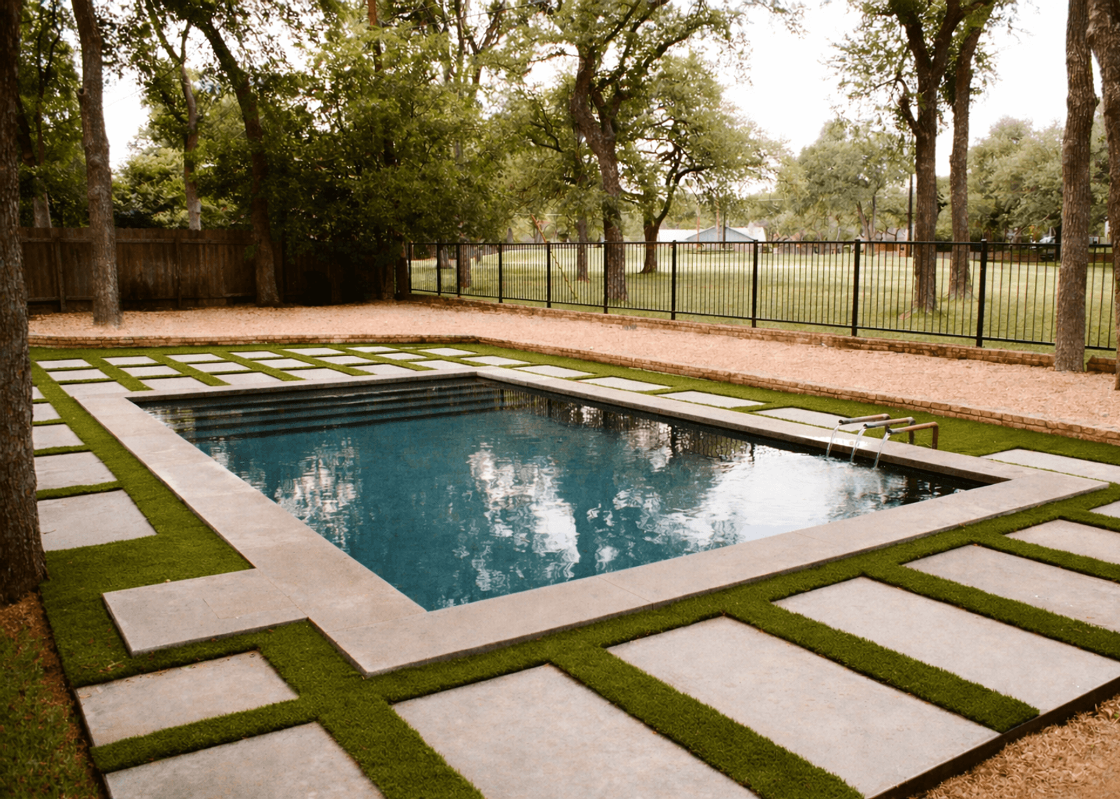 Golden Hour Pools Grand in San Antonio, featuring geometric pavers with grass strips and oaks and gunite plaster finish