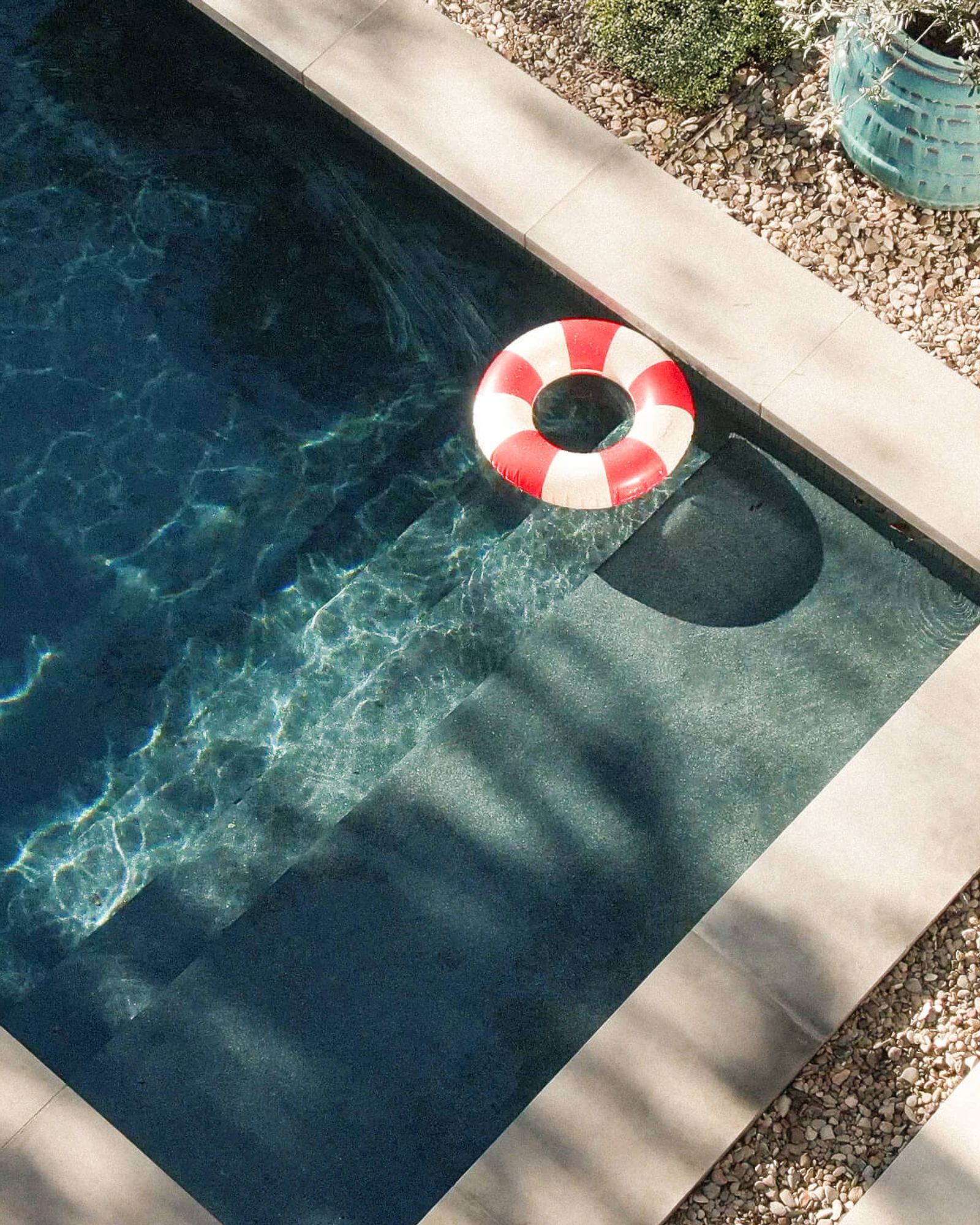 Golden Hour Pools Classic in Austin, featuring striped pool float on crystal blue water and gunite plaster finish