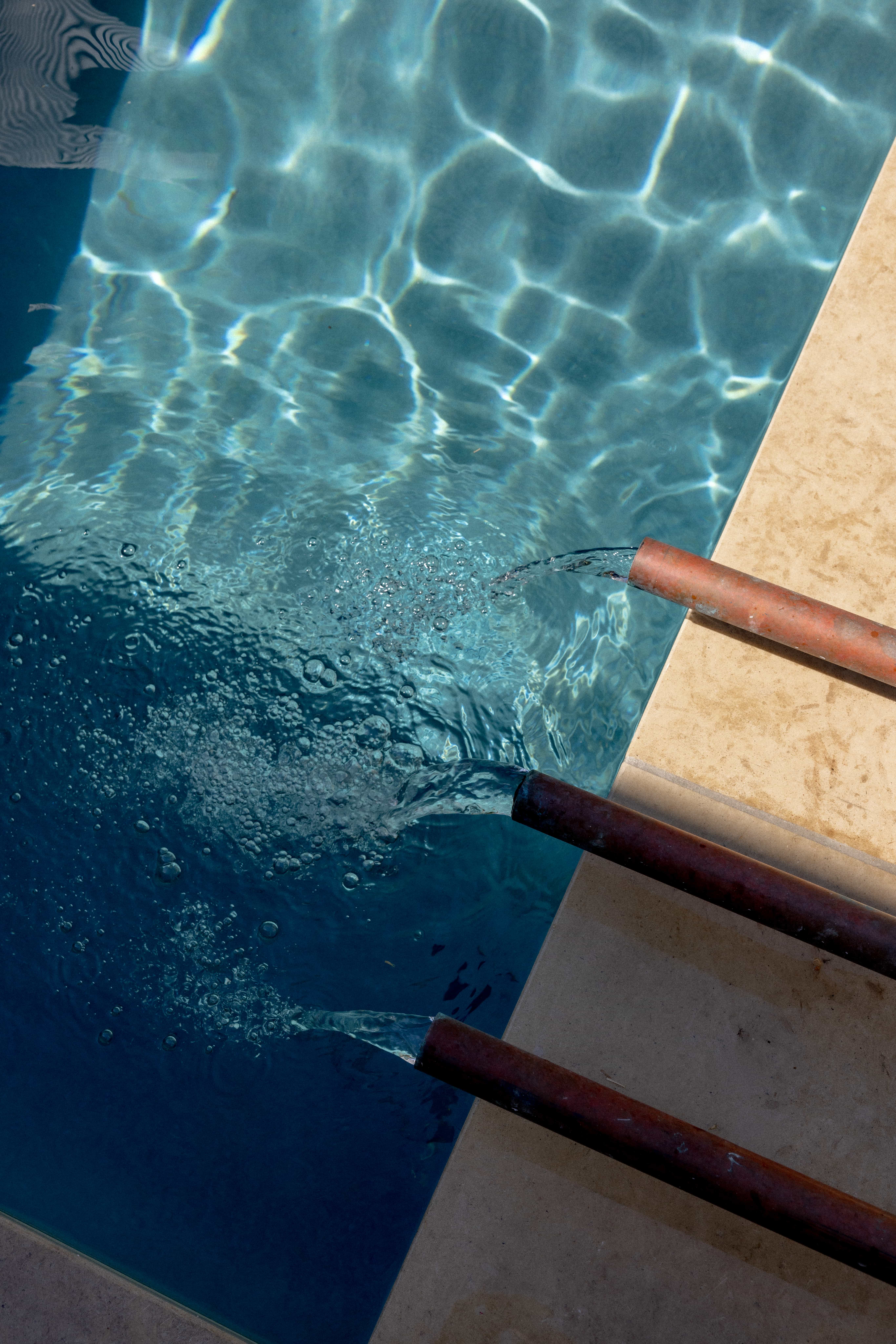Golden Hour Pools Classic in Austin, featuring copper fountain spouts with limestone coping and gunite plaster finish