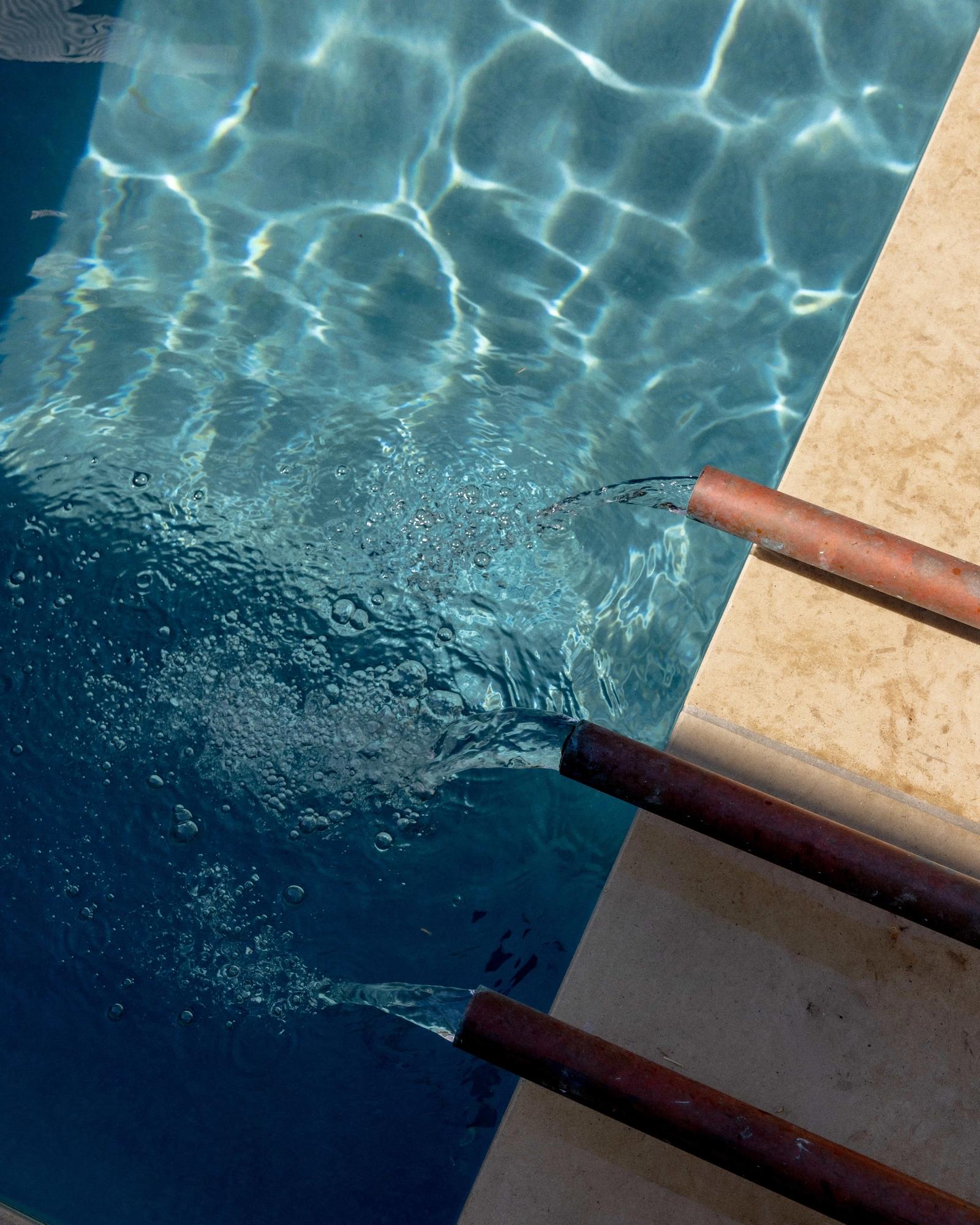 Golden Hour Pools Classic in Austin, featuring copper fountain spouts with limestone coping and gunite plaster finish
