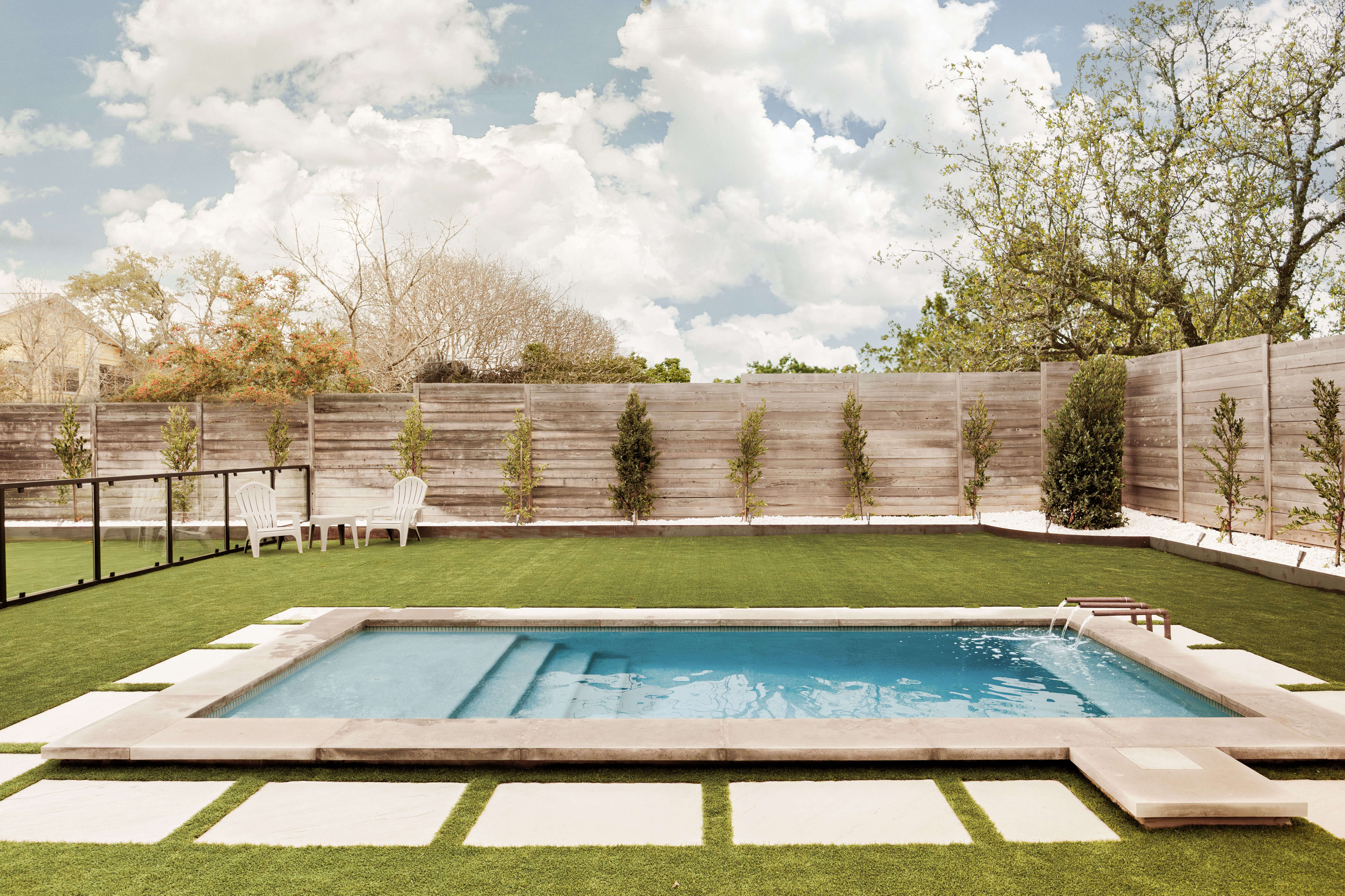 Golden Hour Pools Classic in Dallas, featuring green lawn with stepping stones and fountain and gunite plaster finish