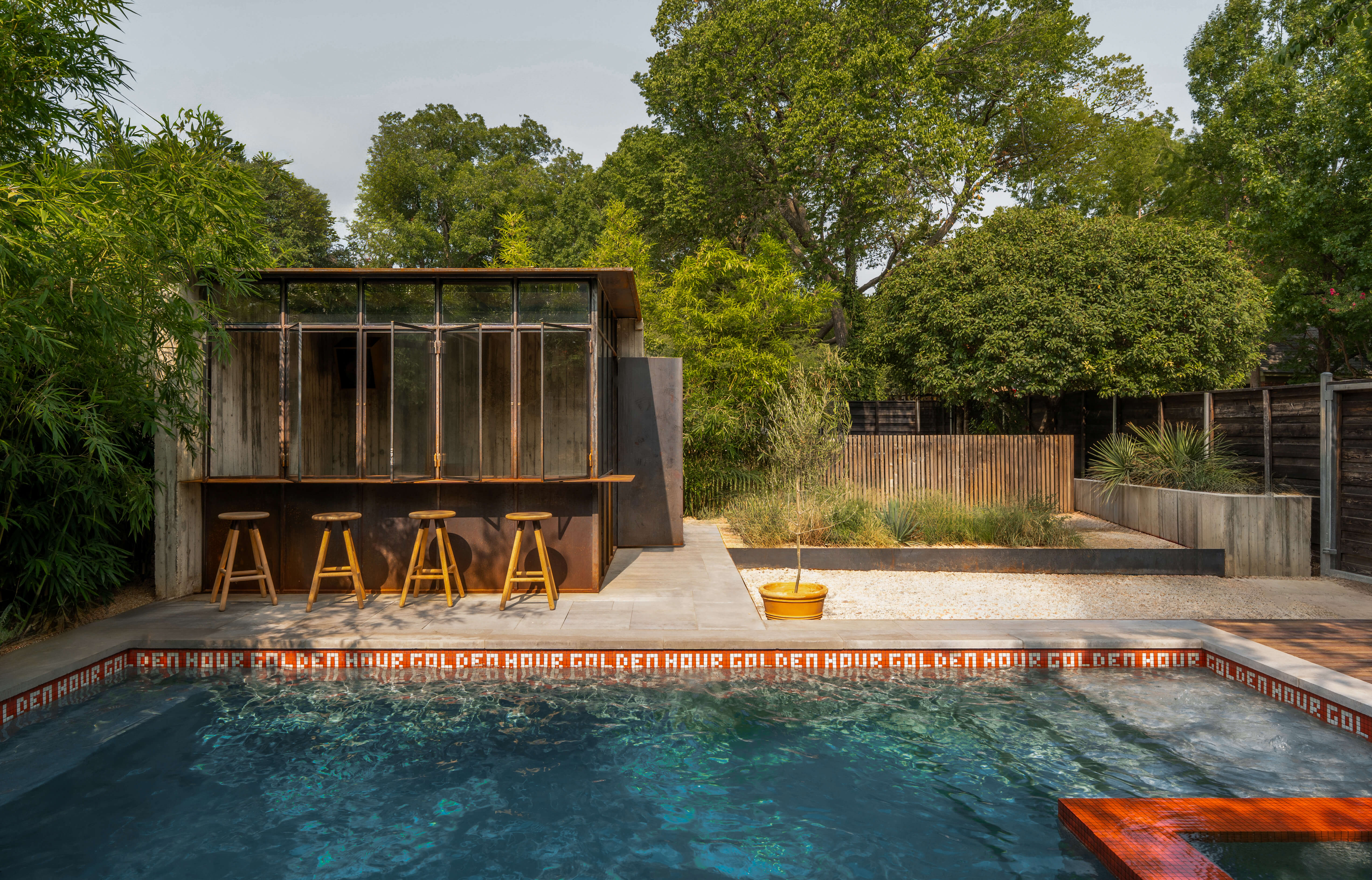 Custom orange tile pool edge and bar seating at the Golden Hour Dallas pool house