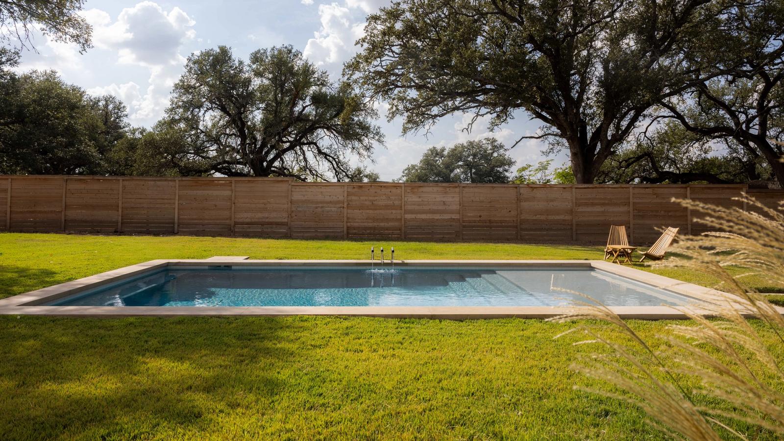 Golden Hour Pools Grand in Waco, featuring couple relaxing on tanning ledge and gunite plaster finish