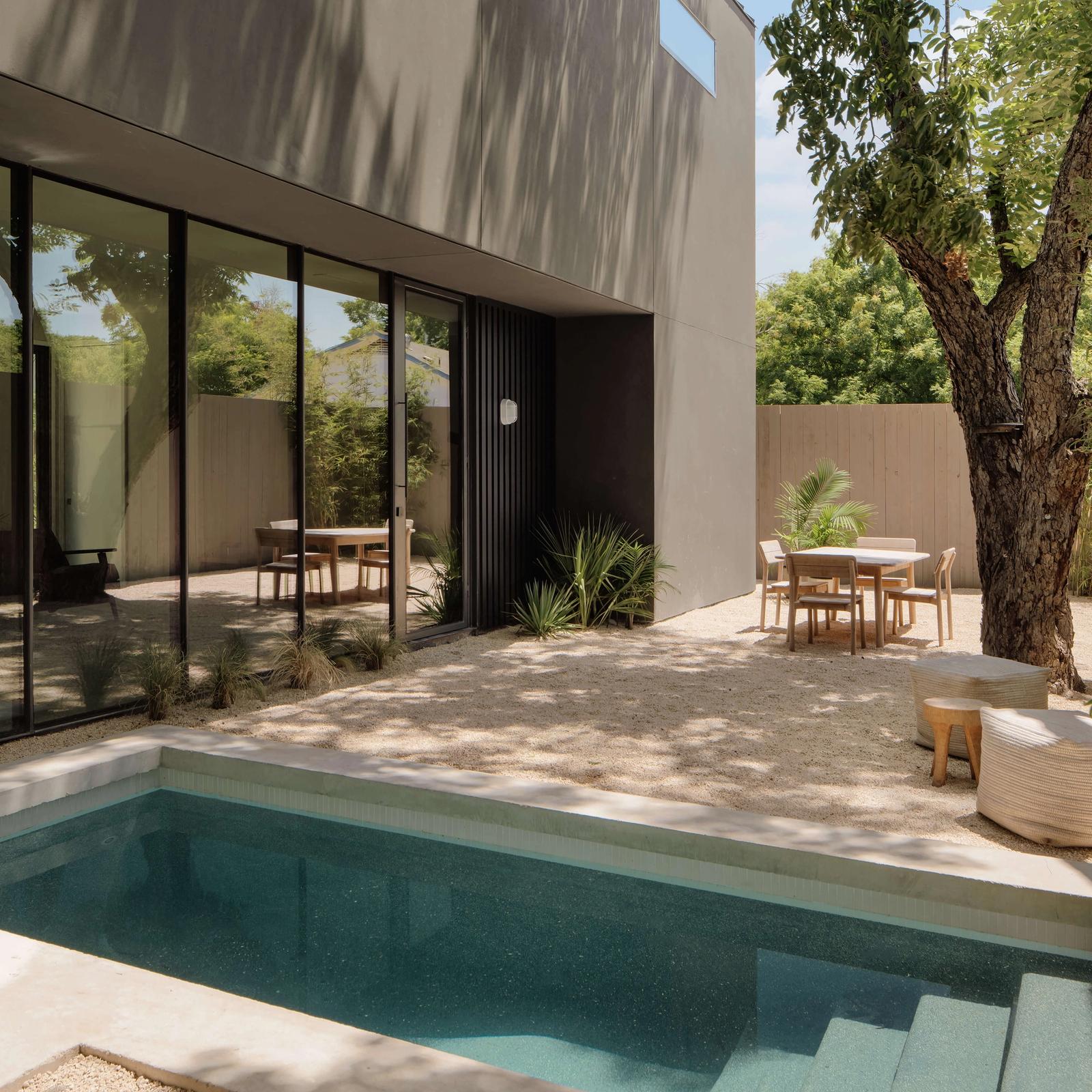 Golden Hour Pools Mini in Austin, featuring modern courtyard with outdoor dining and gunite plaster finish