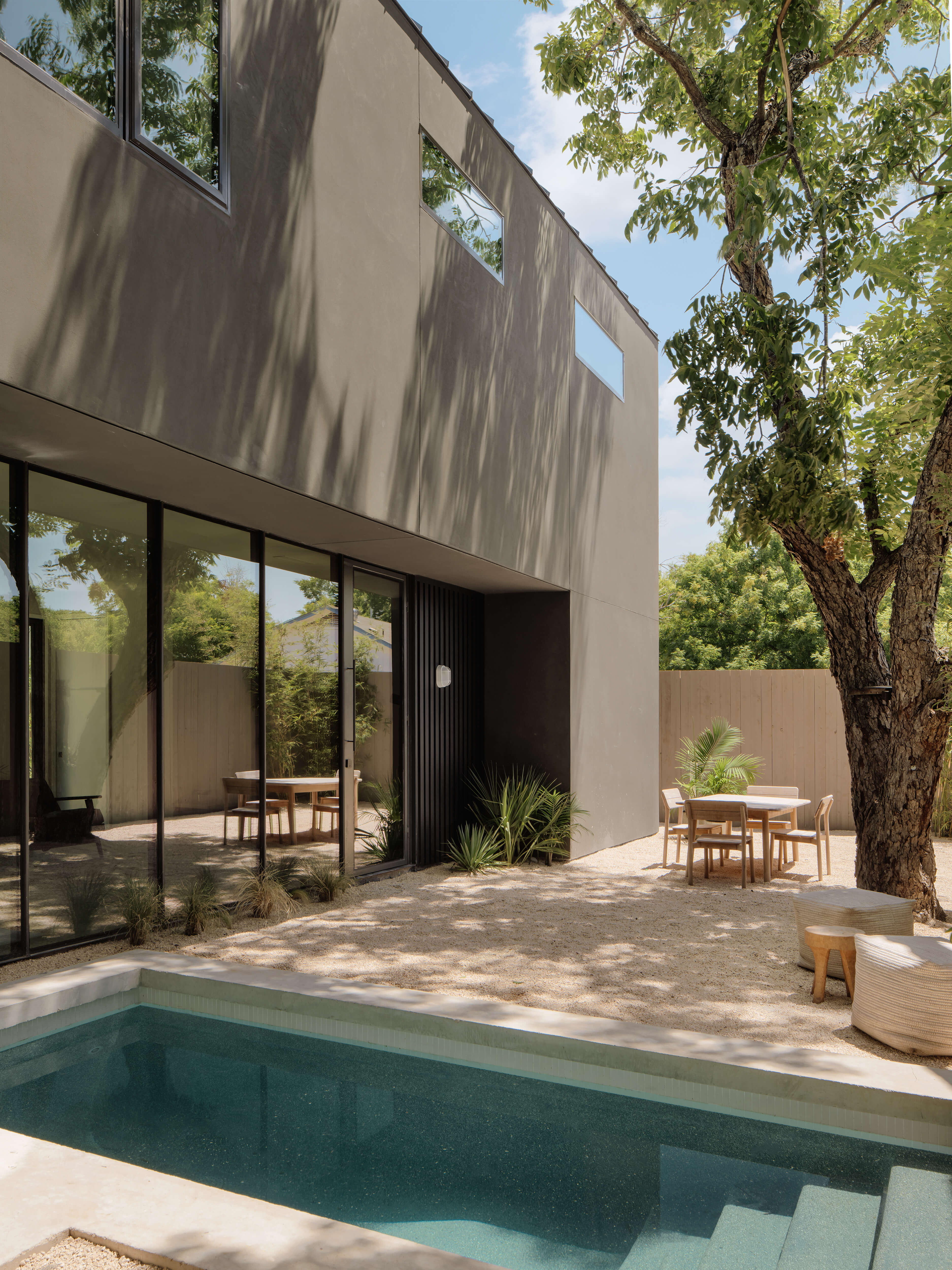 Golden Hour Pools Mini in Austin, featuring modern courtyard with outdoor dining and gunite plaster finish