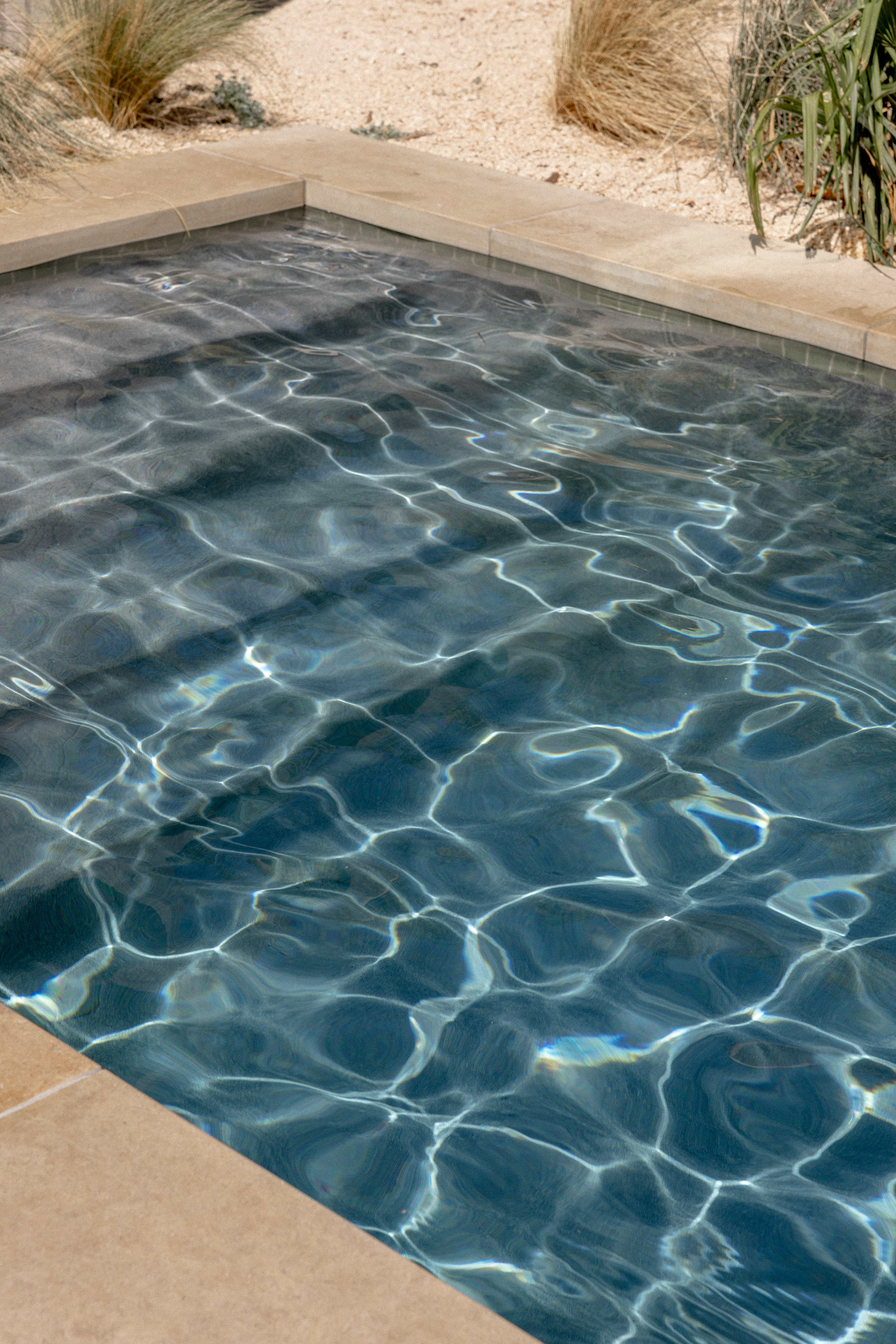Golden Hour Pools Classic in Austin, featuring sunlight patterns on water surface and gunite plaster finish