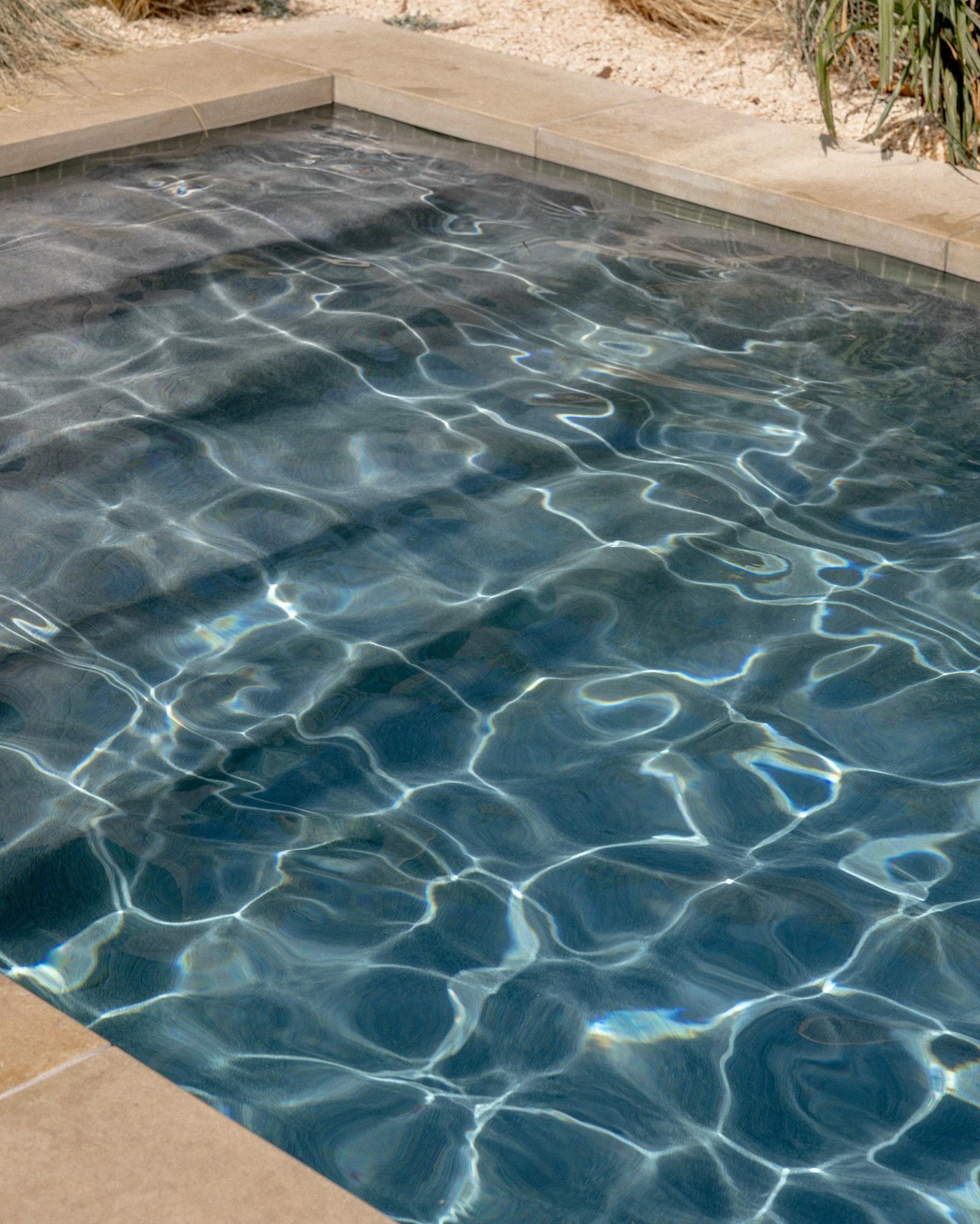 Golden Hour Pools Classic in Austin, featuring sunlight patterns on water surface and gunite plaster finish