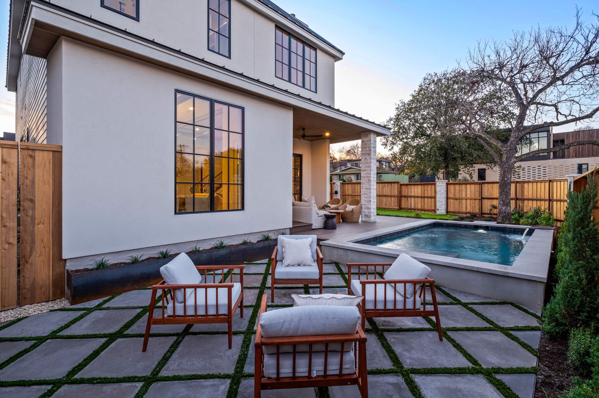 Golden Hour Pools Custom in Austin, featuring four patio chairs arranged for conversation and gunite plaster finish