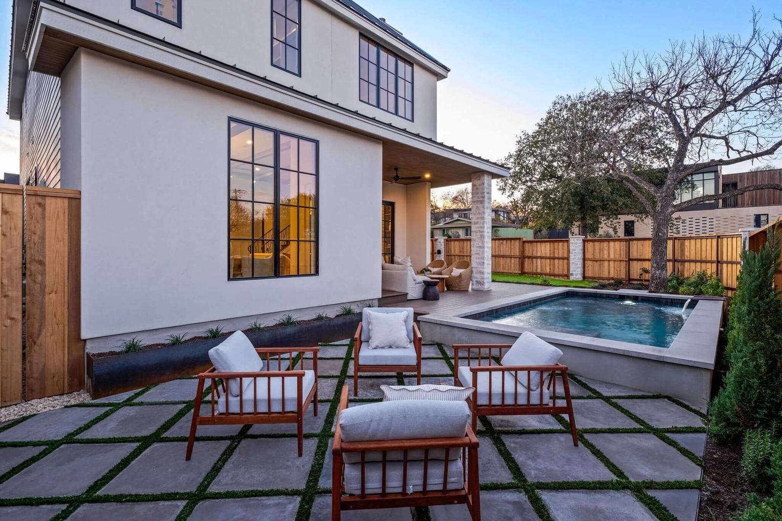 Golden Hour Pools Custom in Austin, featuring four patio chairs arranged for conversation and gunite plaster finish