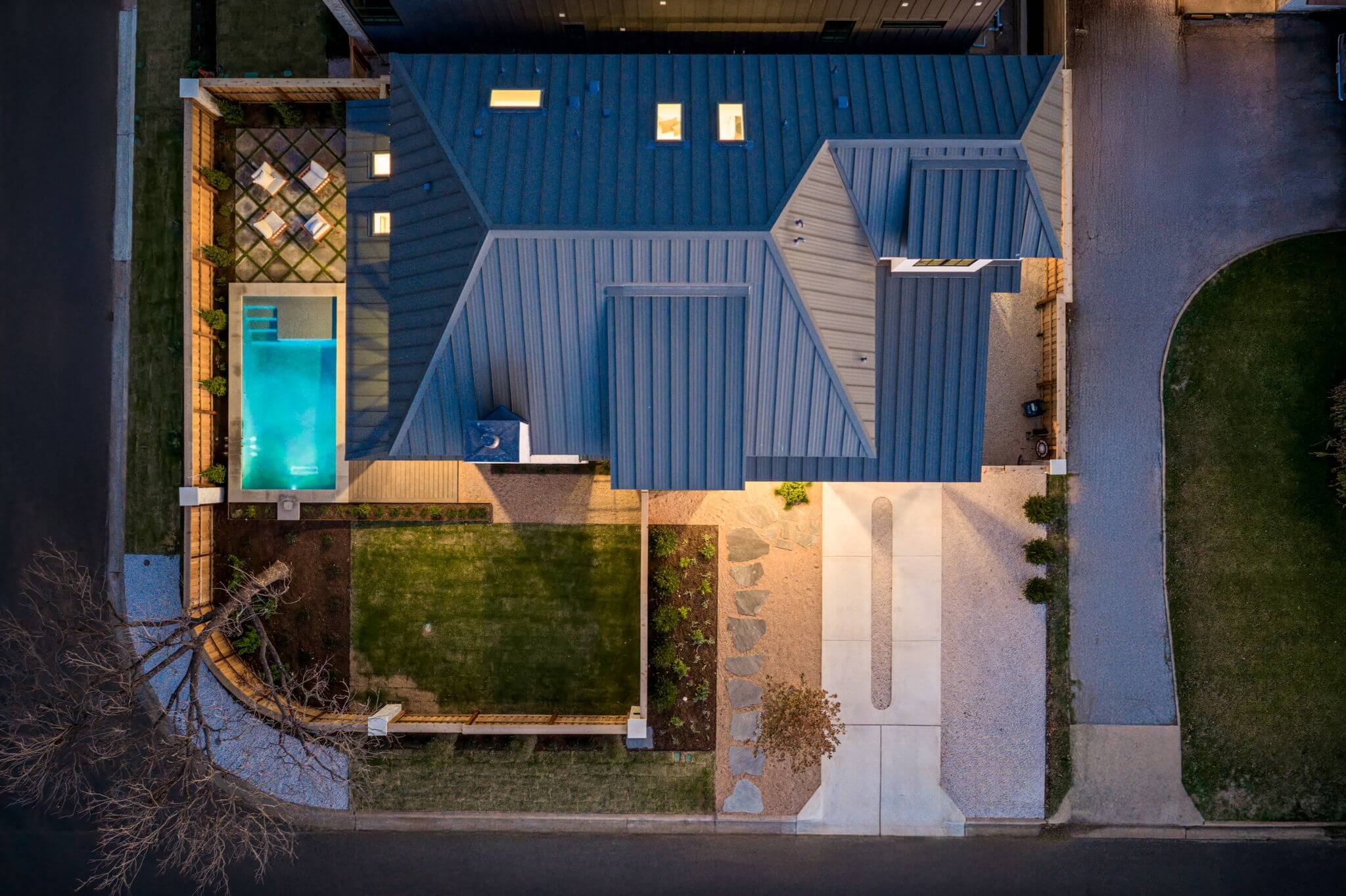 Golden Hour Pools Custom in Austin, featuring tanning ledge and arborvitae hedge and gunite plaster finish