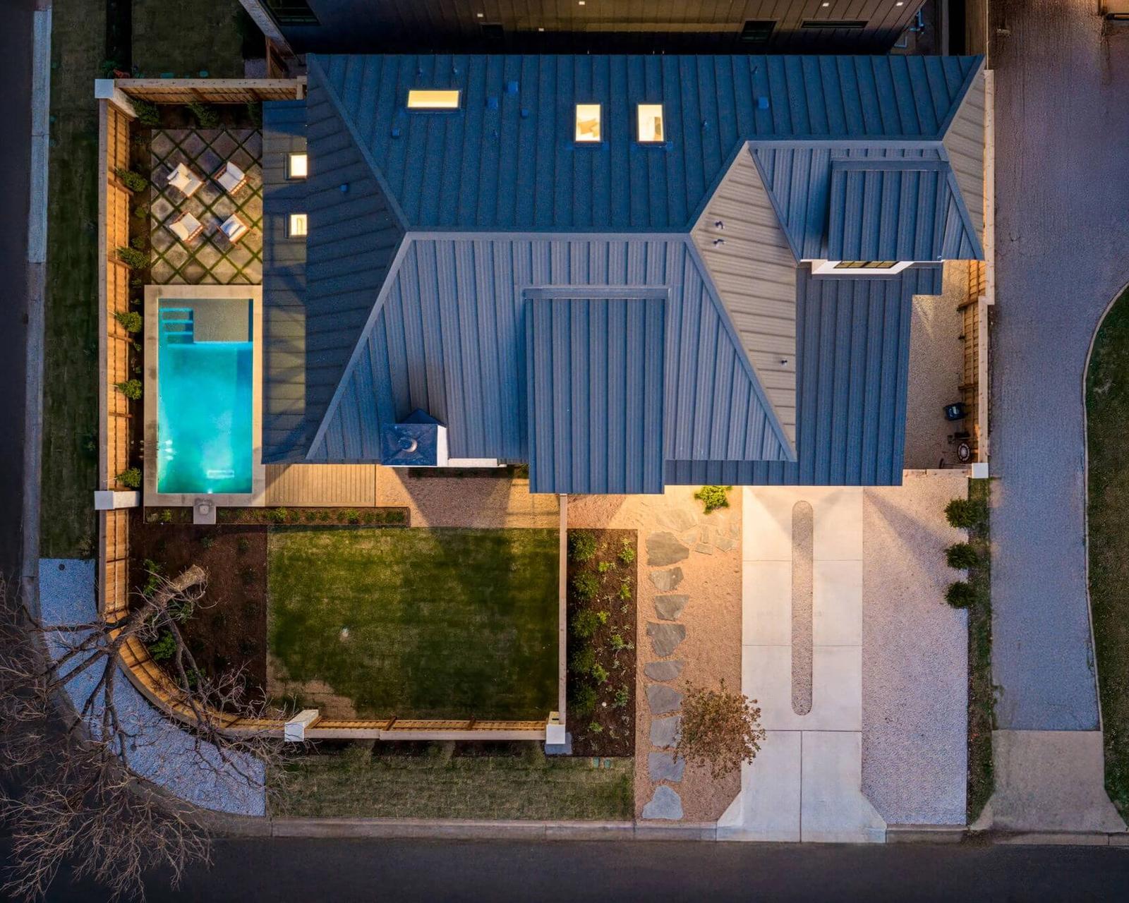 Golden Hour Pools Custom in Austin, featuring tanning ledge and arborvitae hedge and gunite plaster finish