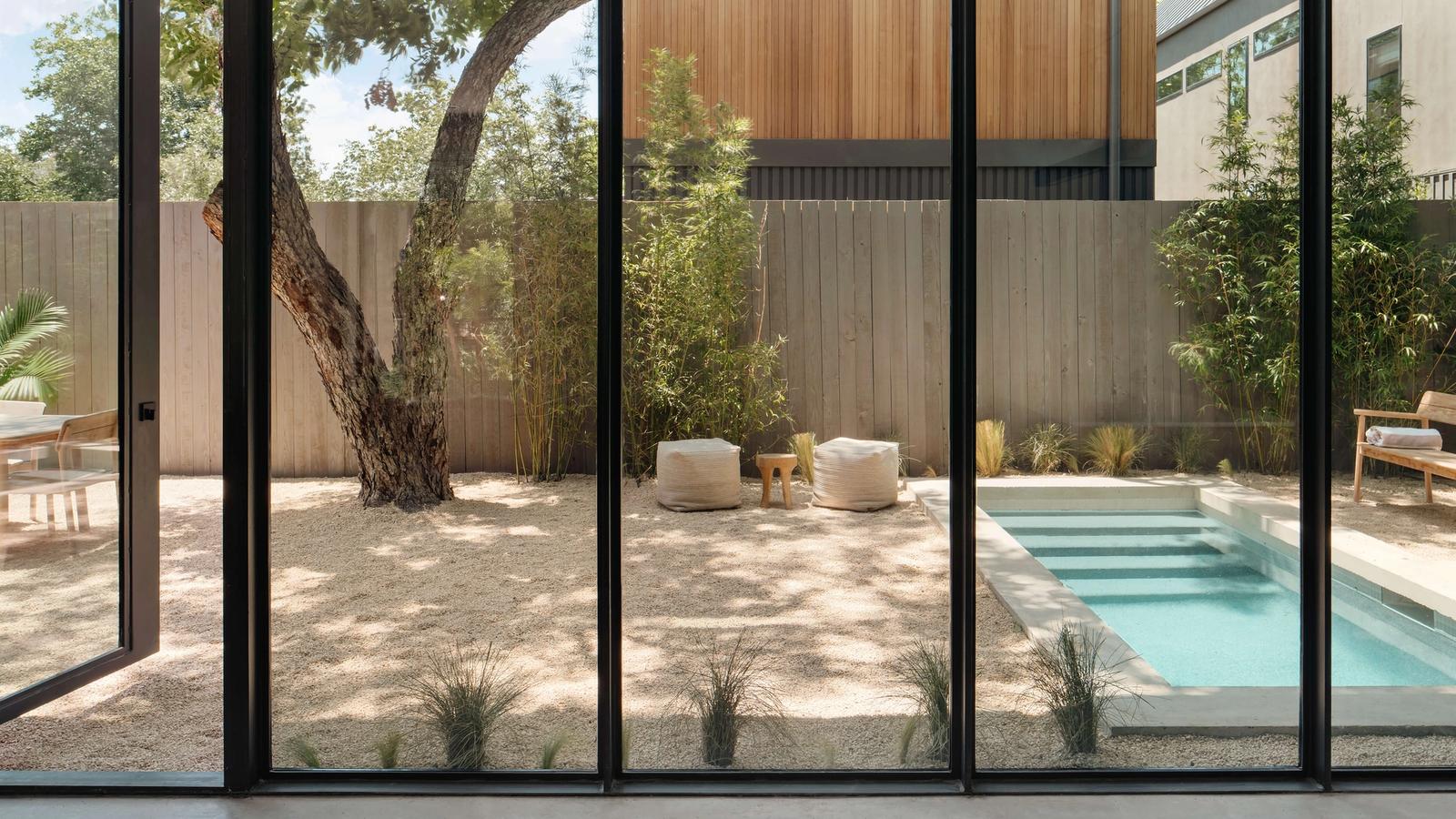 Golden Hour Pools Mini in Austin, featuring indoor-outdoor living through floor-to-ceiling glass and gunite plaster finish