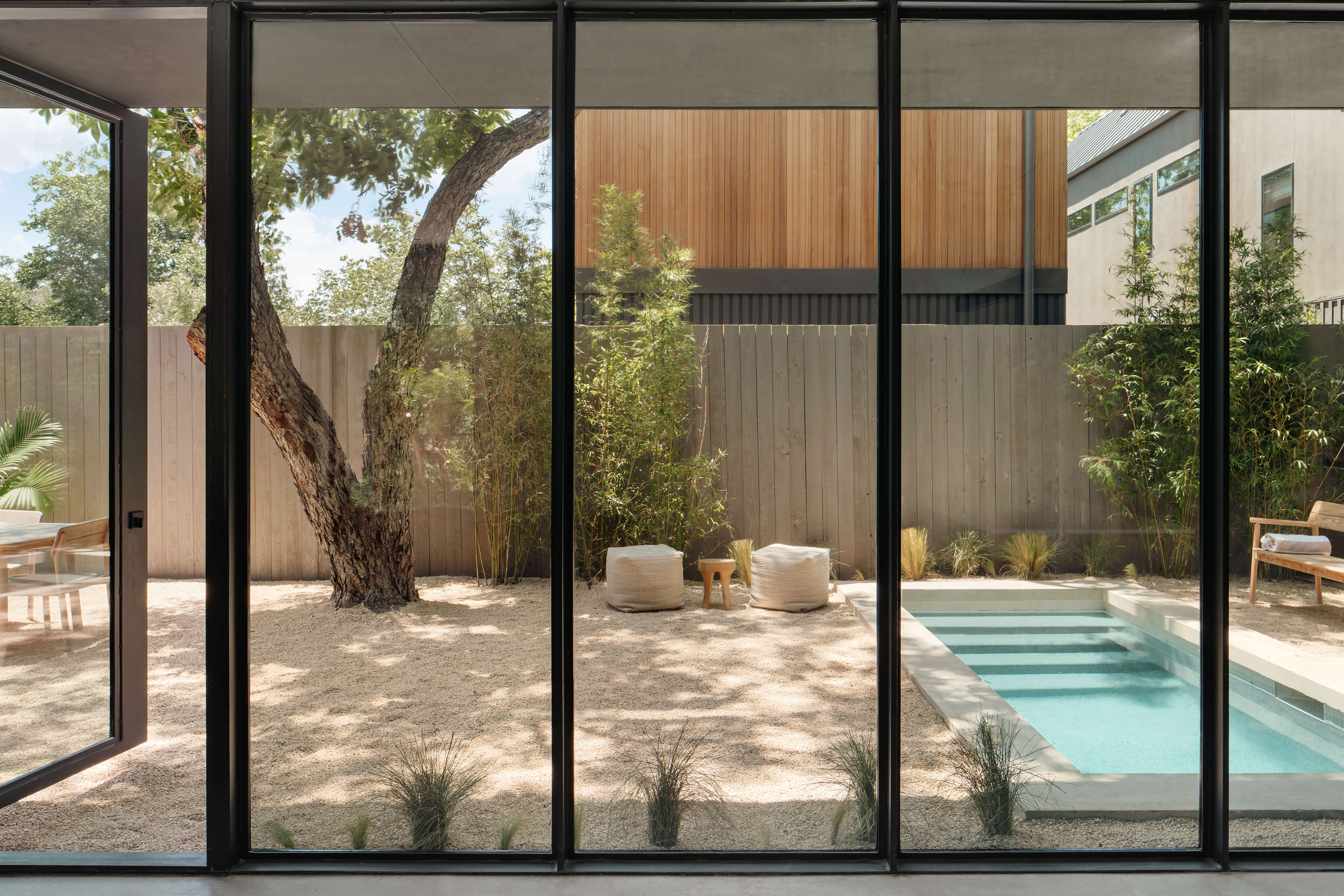 Golden Hour Pools Mini in Austin, featuring indoor-outdoor living through floor-to-ceiling glass and gunite plaster finish