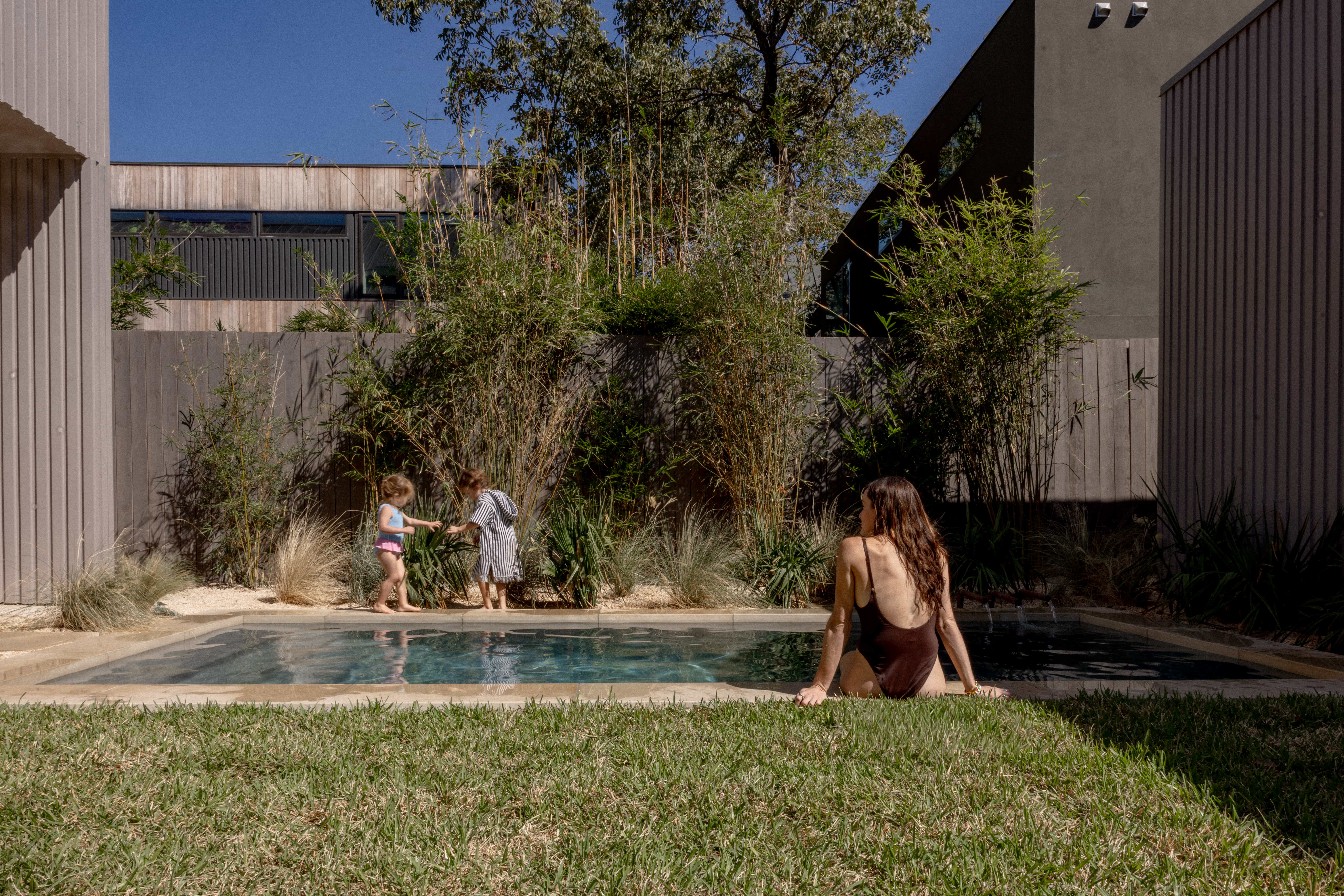Golden Hour Pools Classic in Austin, featuring family moment with kids and bamboo garden and gunite plaster finish