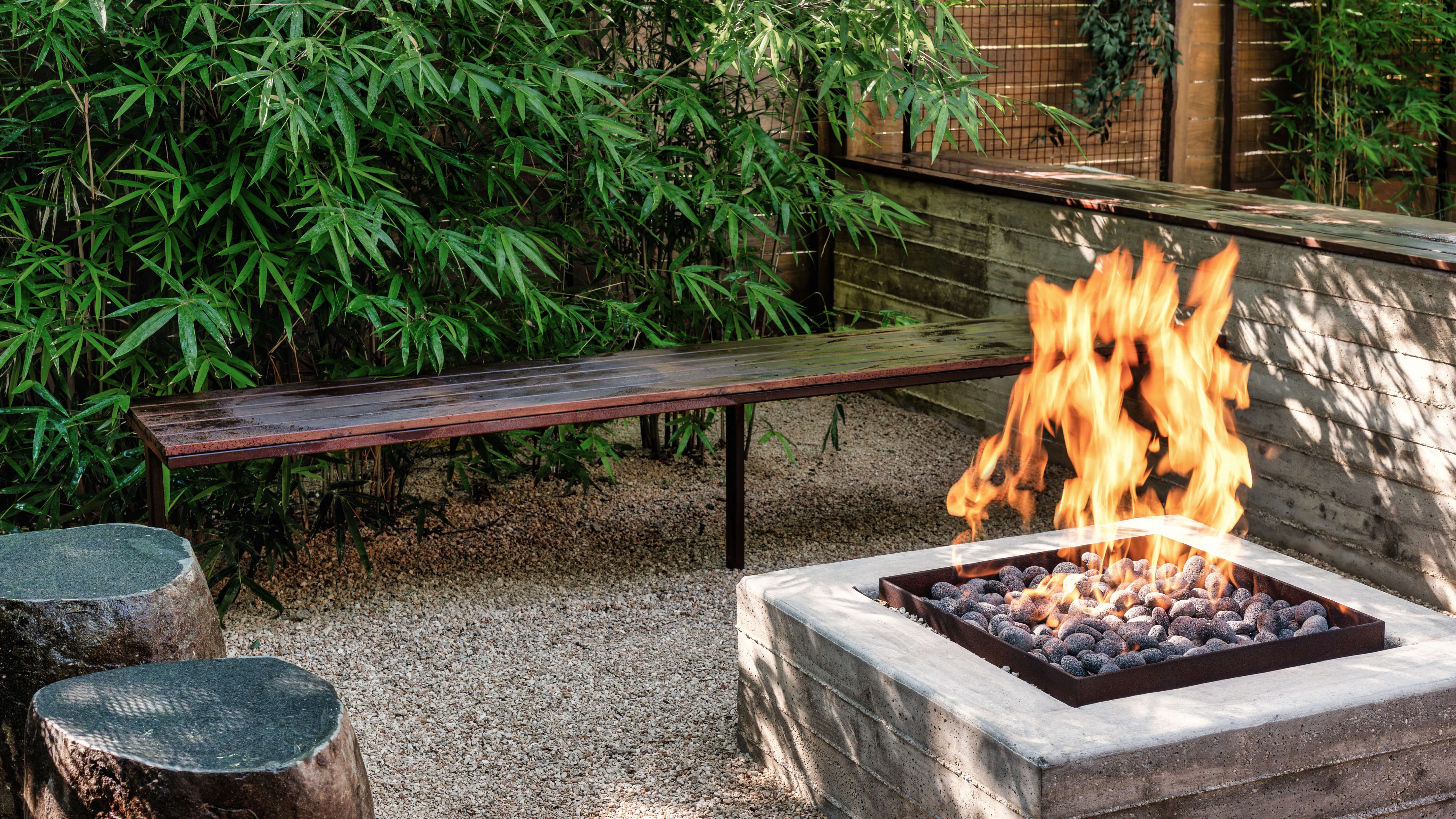 Golden Hour Pools Classic in Austin, featuring concrete fire pit with bamboo garden and wood retaining wall in Zilker