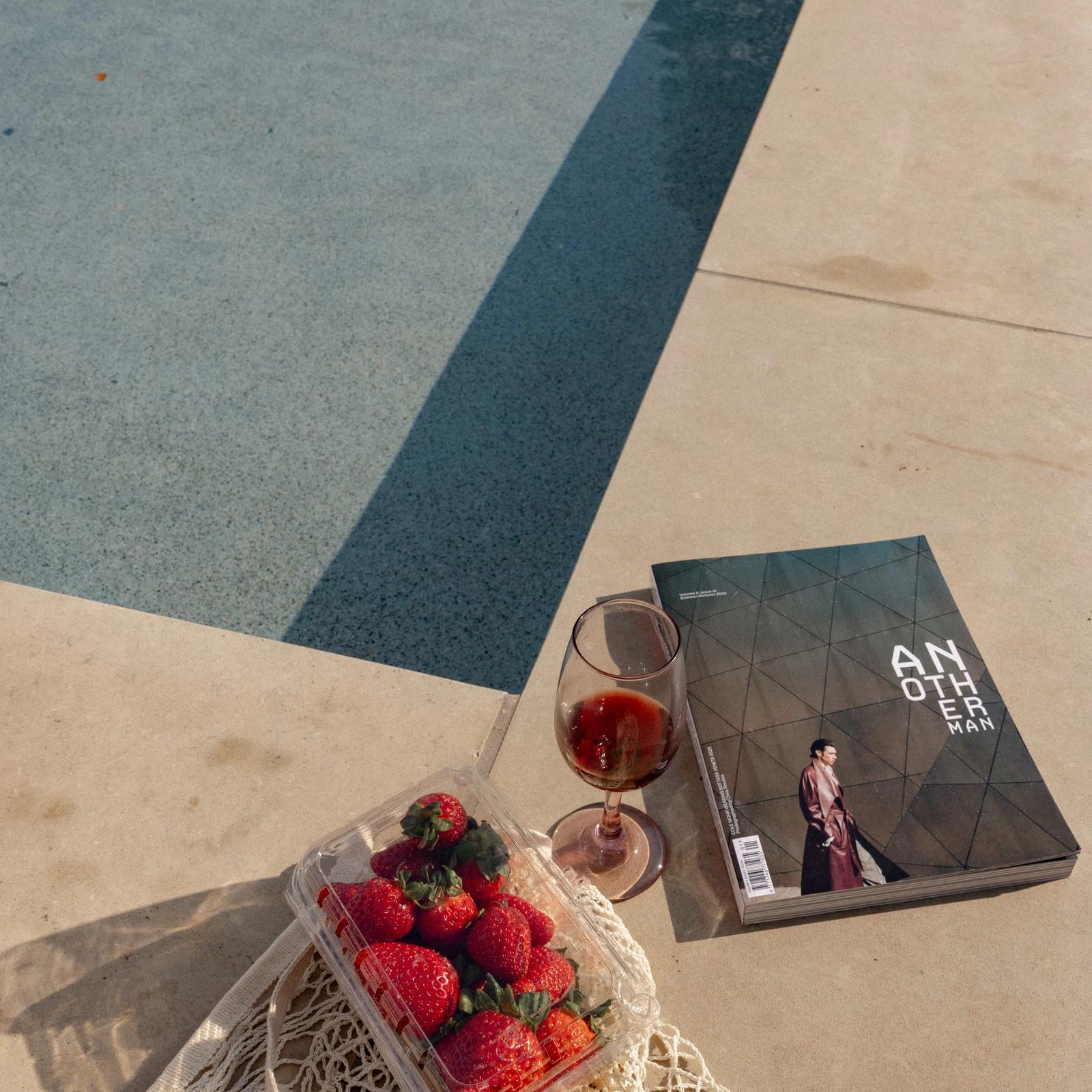 Golden Hour Pools Grand in Waco, featuring strawberries rosé and magazine on pool edge and gunite plaster finish
