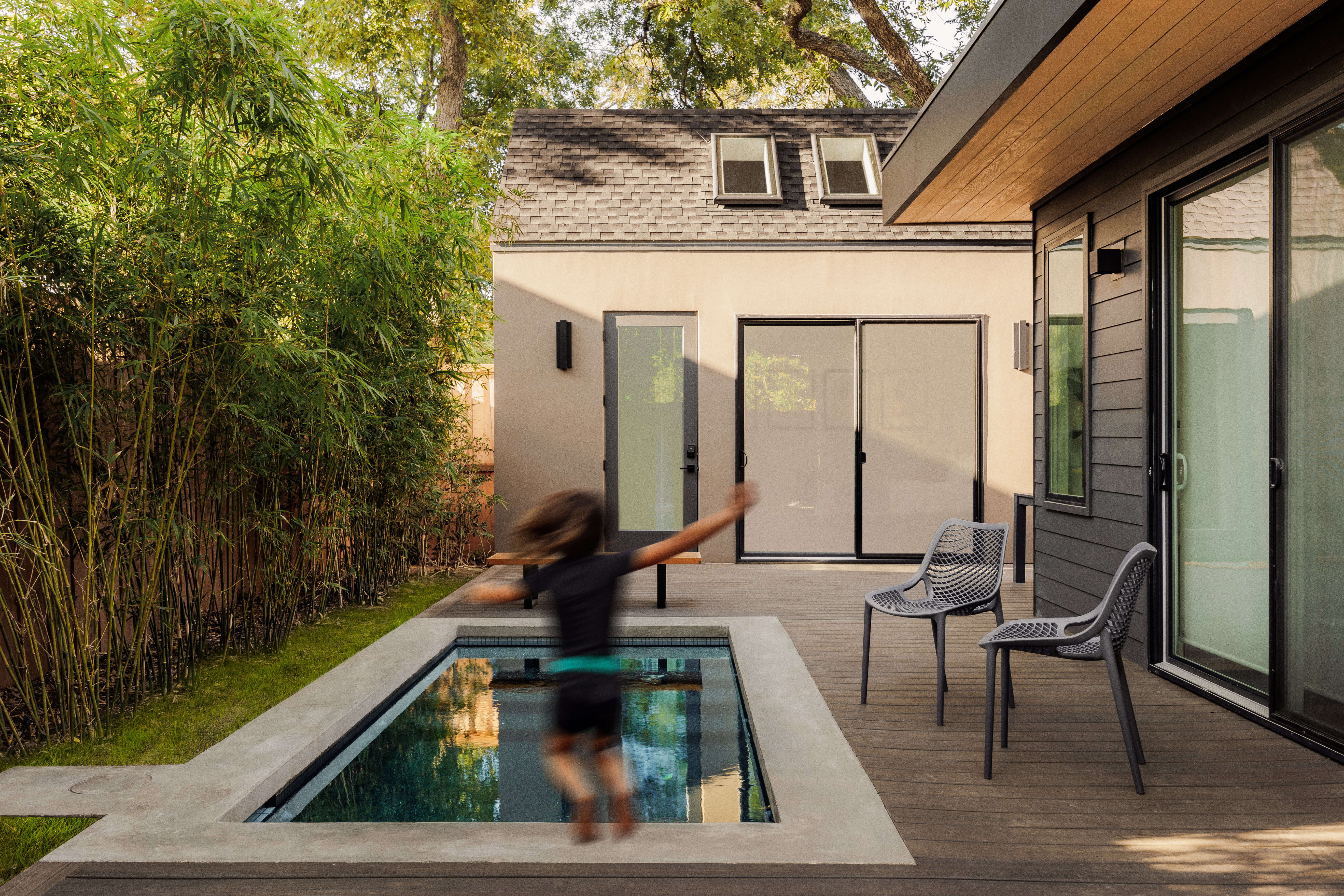 Golden Hour Pools Mini in Austin, featuring motion blur of child jumping into pool with gunite plaster finish