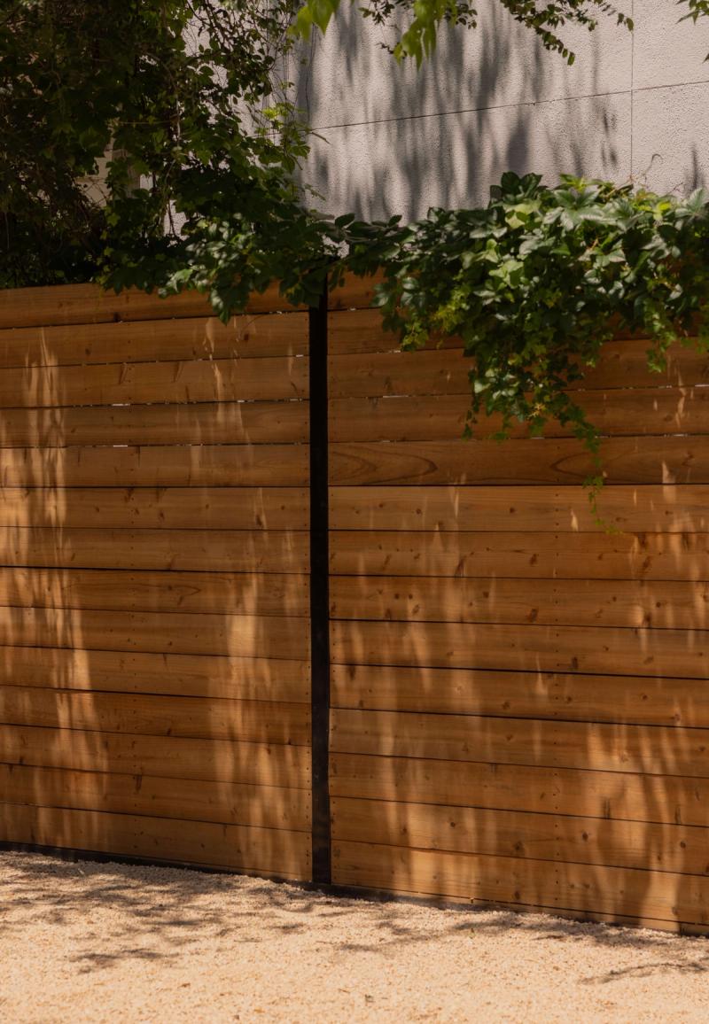 Golden Hour landscape horizontal cedar privacy fence with steel posts and tree canopy