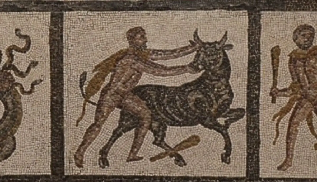 A detail from an ancient mosaic depicting a muscular hero wrestling a bull while another figure holds a club.