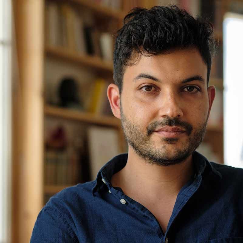 Author portrait of Ferdia Lennon, writer of the novel Glorious Exploits, wearing a dark blue collared shirt indoors.