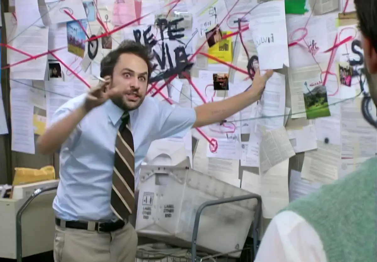 A frantic, wild-eyed man in a light blue shirt and tie gestures toward a chaotic wall covered in papers, photographs, and red string. The words "PEPE SILVIA" are visible on the board behind him.