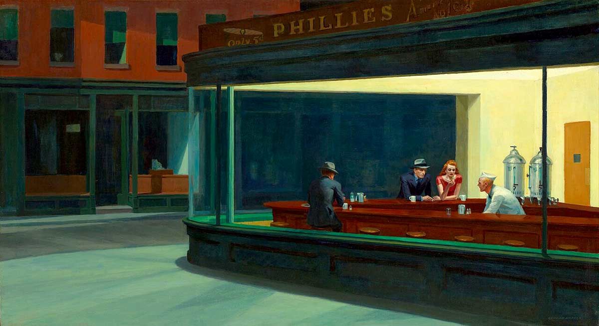 Edward Hopper's painting "Nighthawks," depicting a brightly lit corner diner at night viewed from a dark, deserted street through a large glass window. Inside, three customers sit at the wooden counter—a couple side-by-side and a lone man with his back to the viewer—while a server in a white uniform works behind the counter. A sign above the diner reads "PHILLIES".
