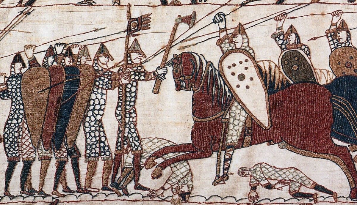 A section of the medieval Bayeux Tapestry showing Anglo-Saxon soldiers forming a shield wall while a Norman knight attacks on horseback during the Battle of Hastings.