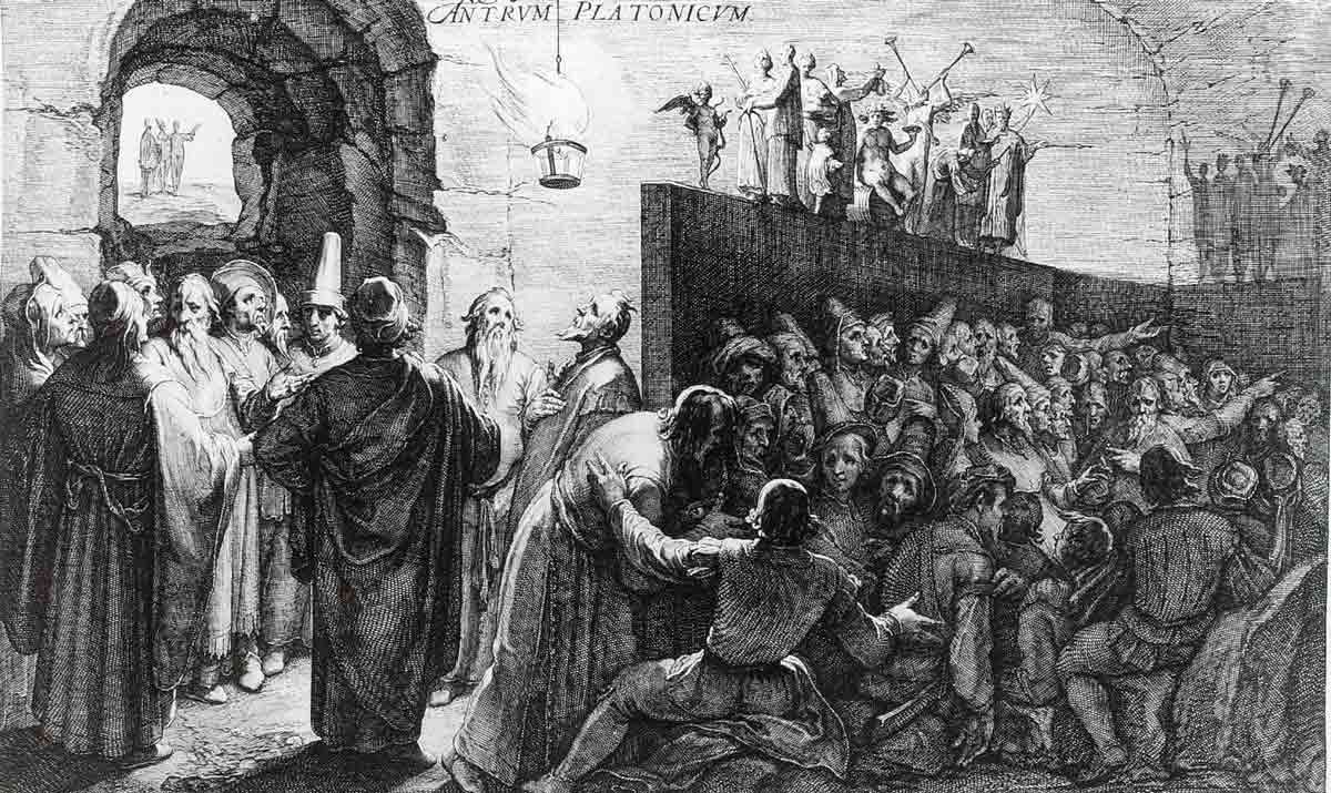 A detailed, classical black-and-white engraving illustrating Plato's Cave, showing chained prisoners gazing at shadows on a cave wall while figures behind a partition hold up statues in front of a blazing fir