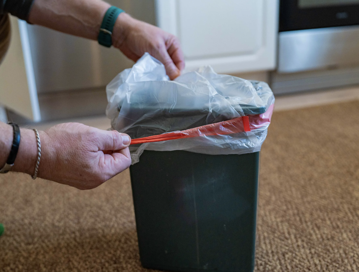Hender trekker en pose ned i en soppelbote