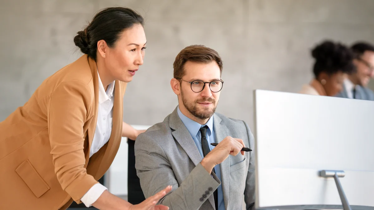 Colleagues collaborating in front of a computer