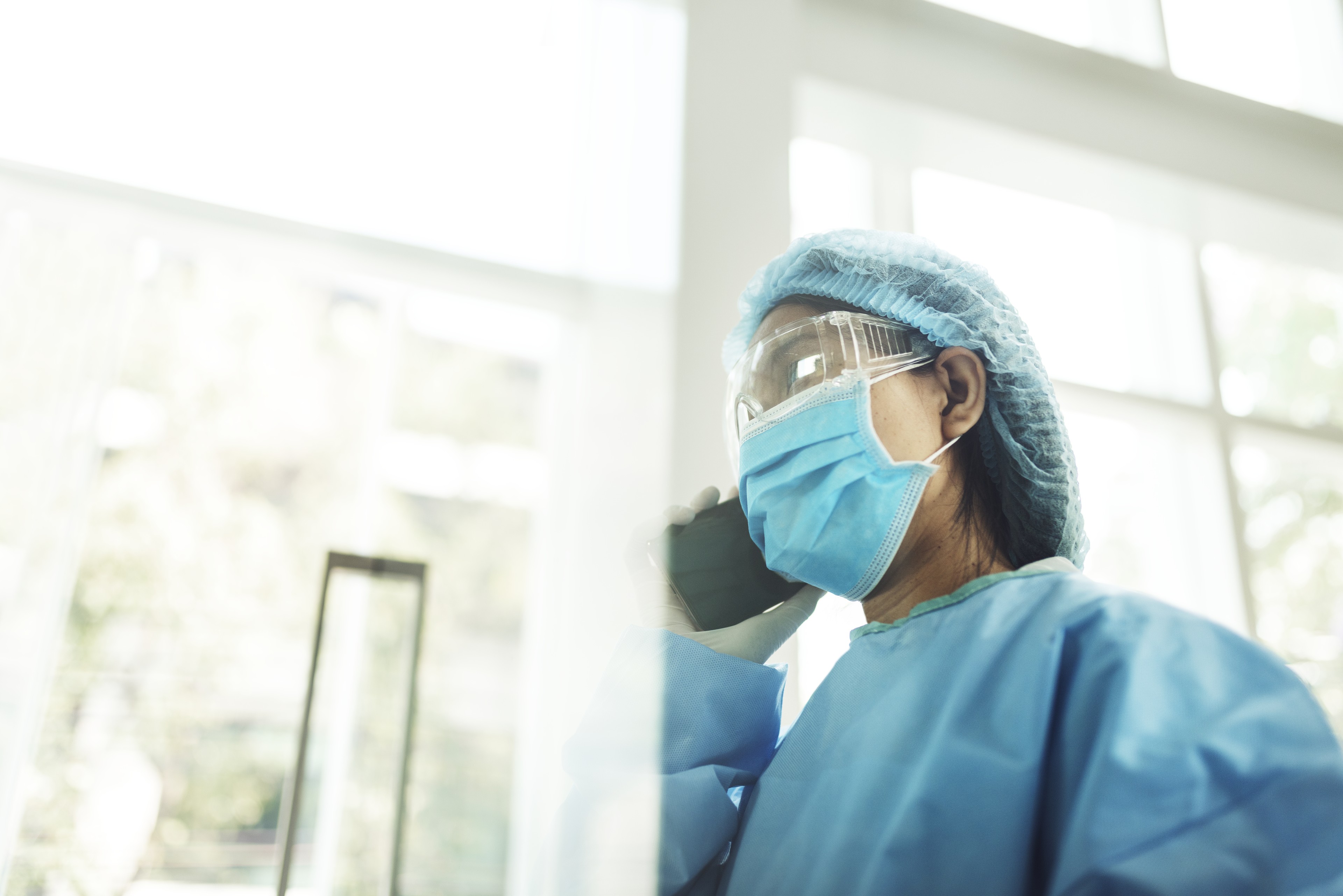 Stock photo of person in medical scrubs, mask, and goggles
