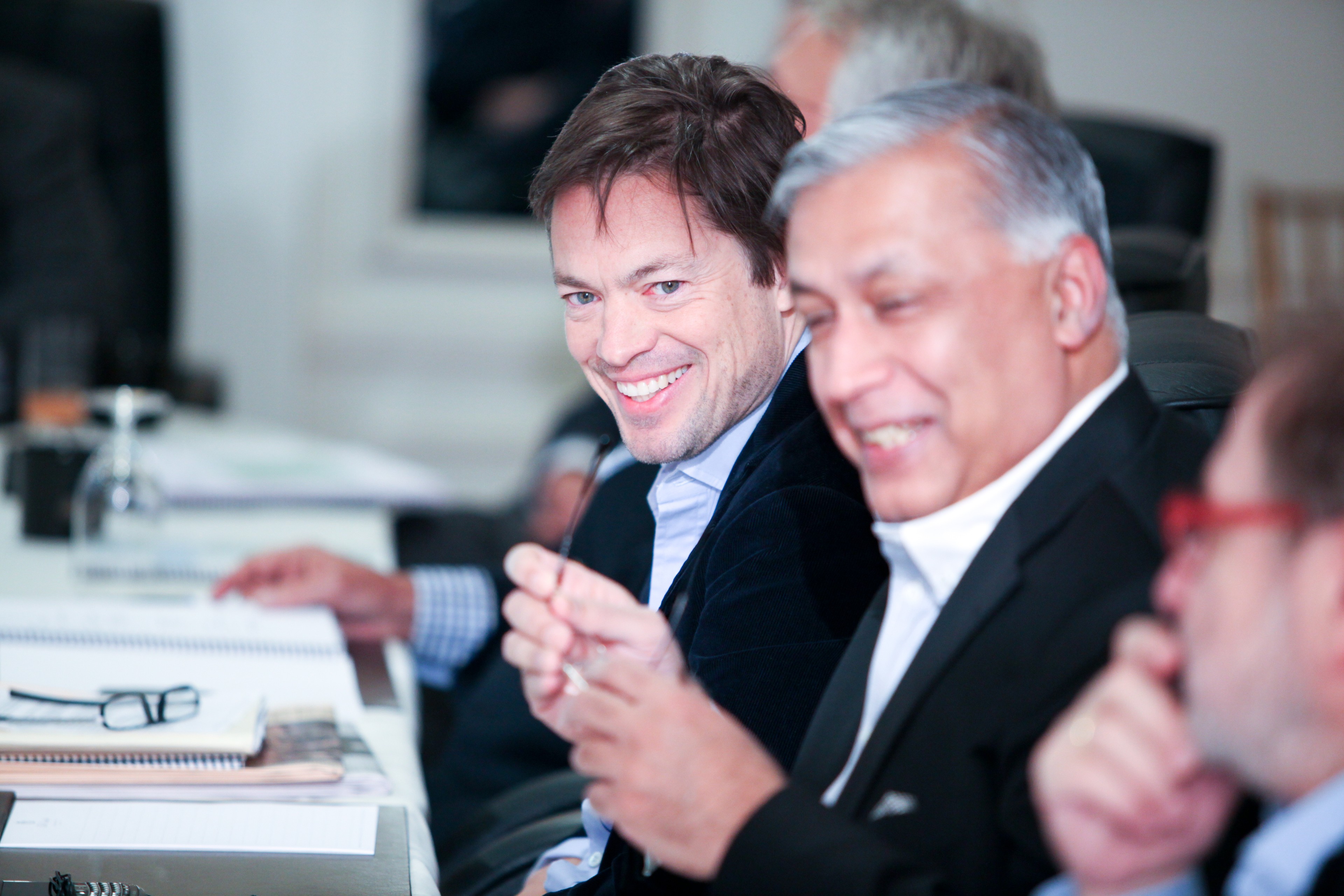Nicolas Berggruen and Shaukat Aziz smile while sitting at a table 