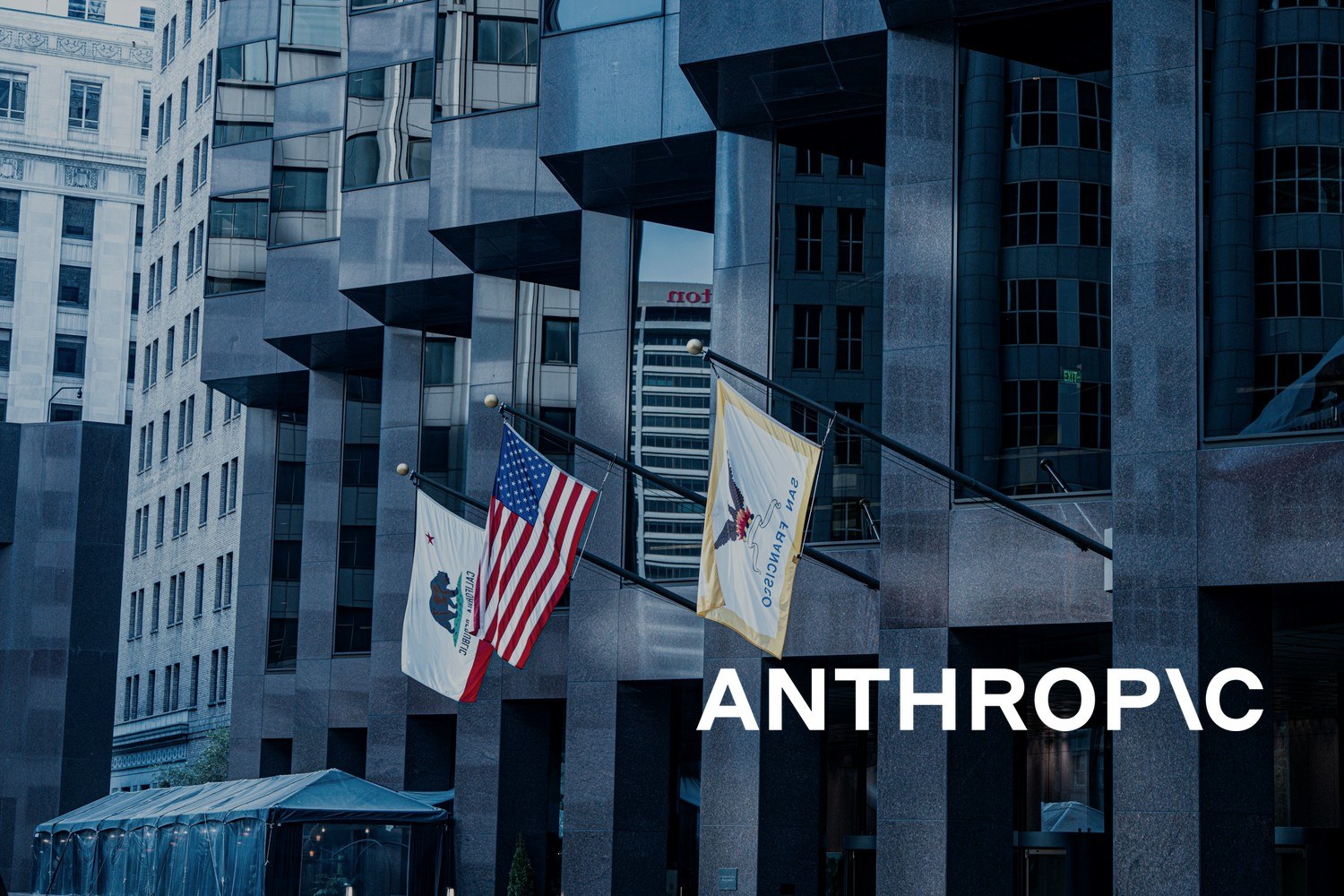 Amerikanske og lokale flagg utenfor moderne kontorbygninger. Med logoen til Anthropic lagt på.