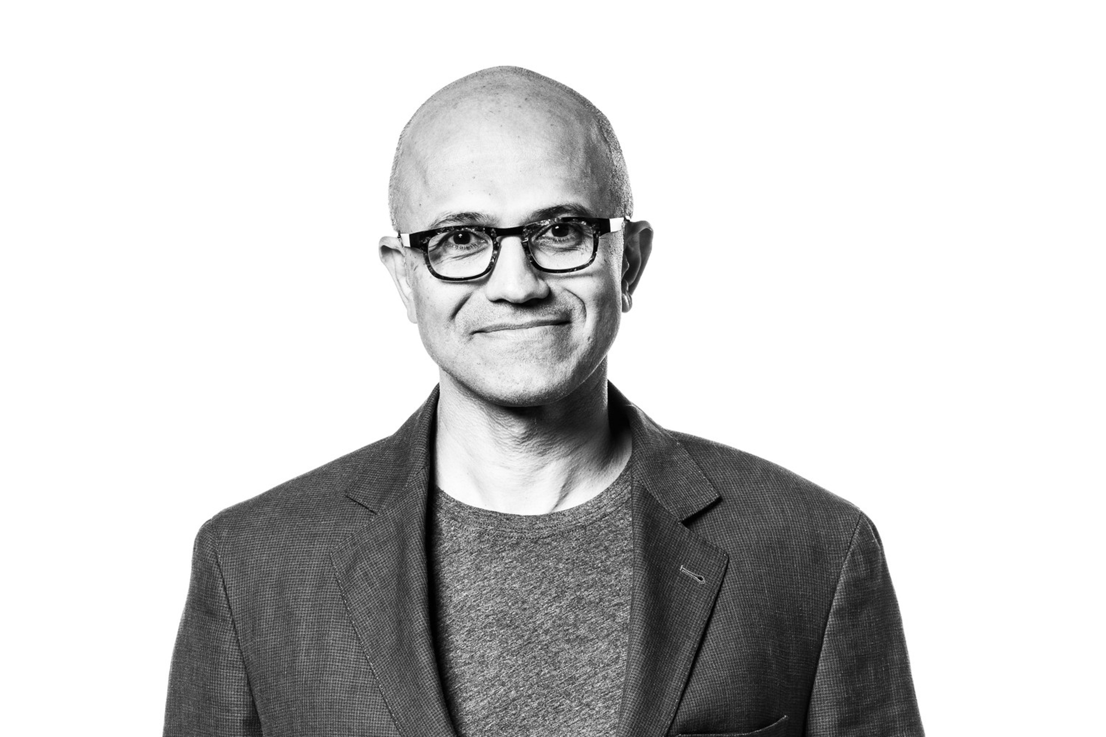Microsoft-sjef Satya Nadella står med hendene i lommene foran en lys bakgrunn.