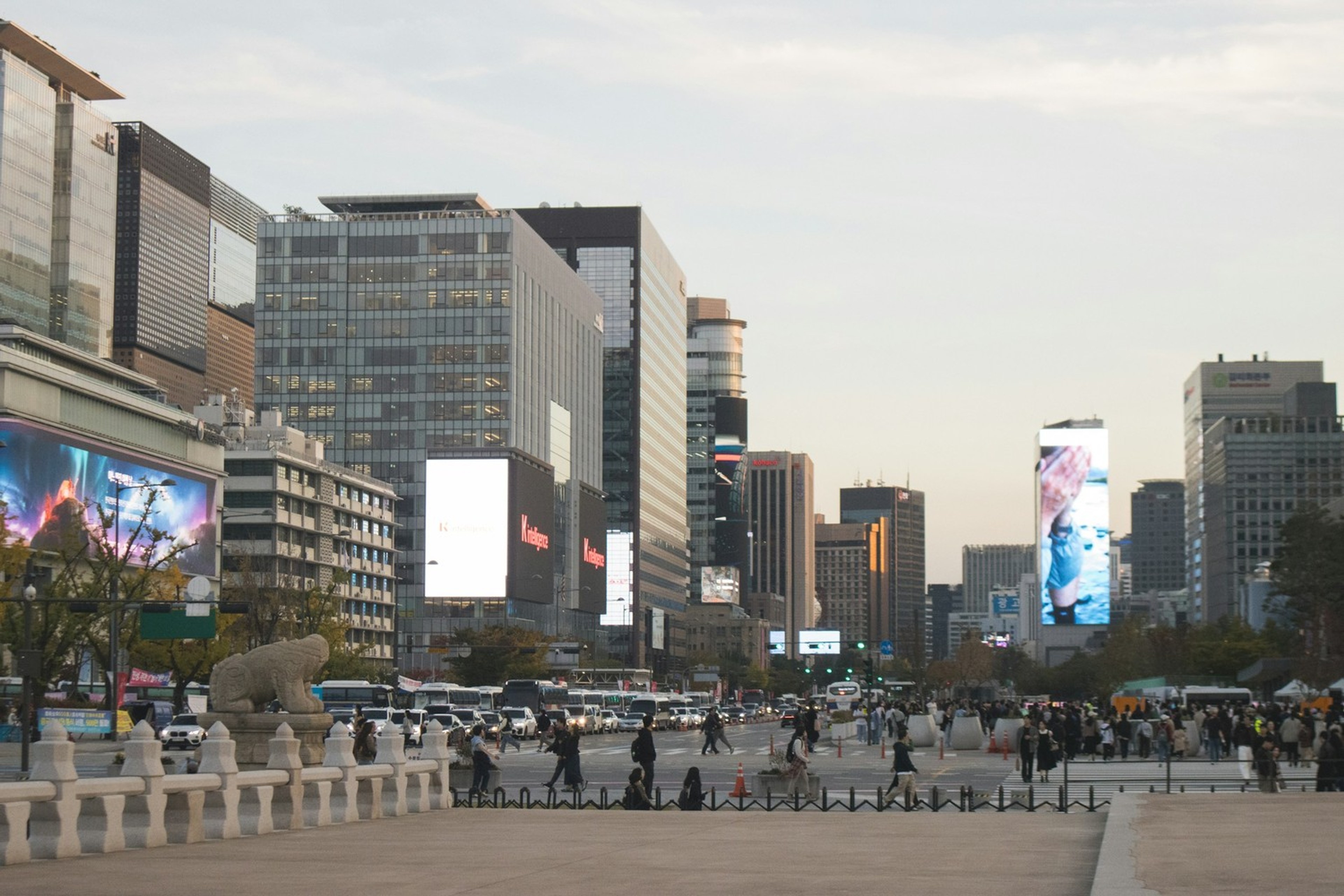 Gwanghwamun-området i Seoul med høyhus, trafikk og digitale reklameskjermer.