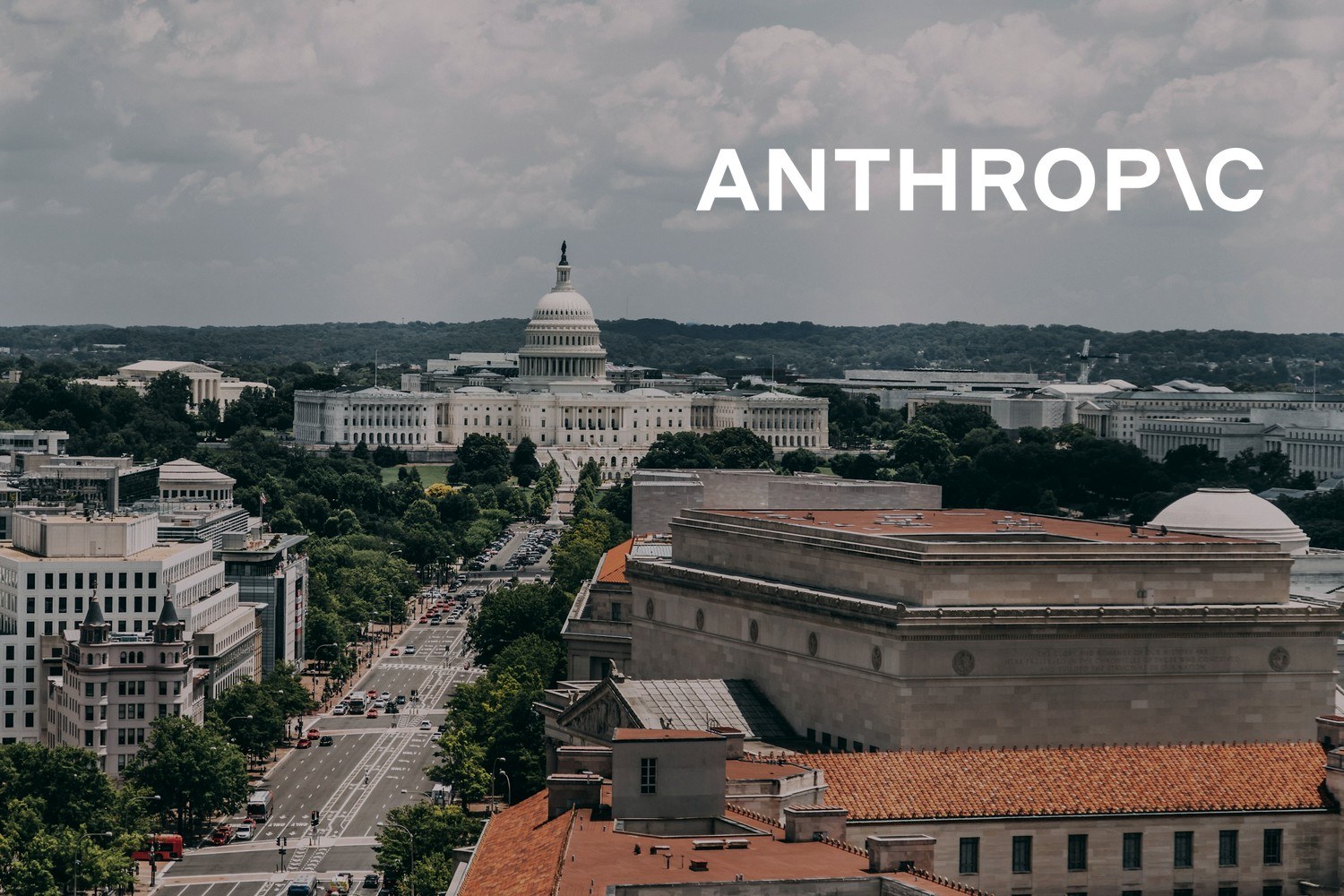 Utsikt mot USAs kongressbygning Capitol i Washington DC, med bybebyggelse og en bred gate i forgrunnen. Med logoen til Anthropic lagt på.