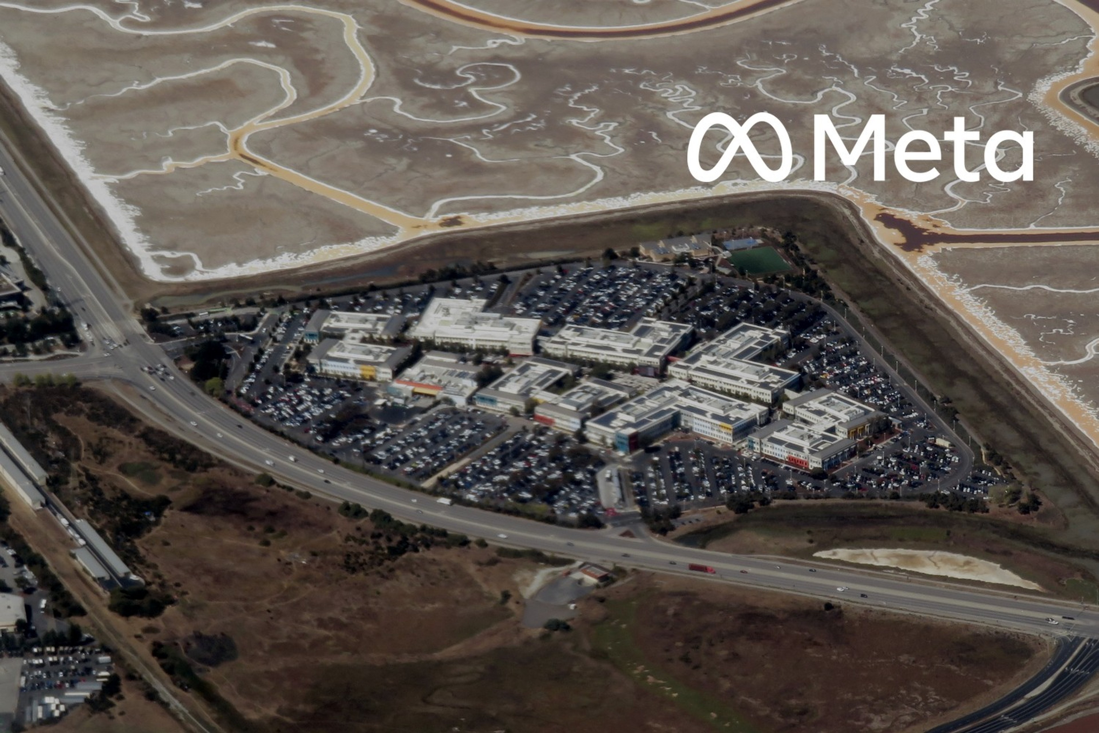 Flyfoto av Metas tidligere Facebook-campus i Menlo Park i California. Med logoen til Meta lagt på.