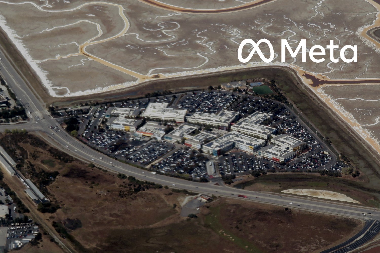 Flyfoto av Metas tidligere Facebook-campus i Menlo Park i California. Med logoen til Meta lagt på.