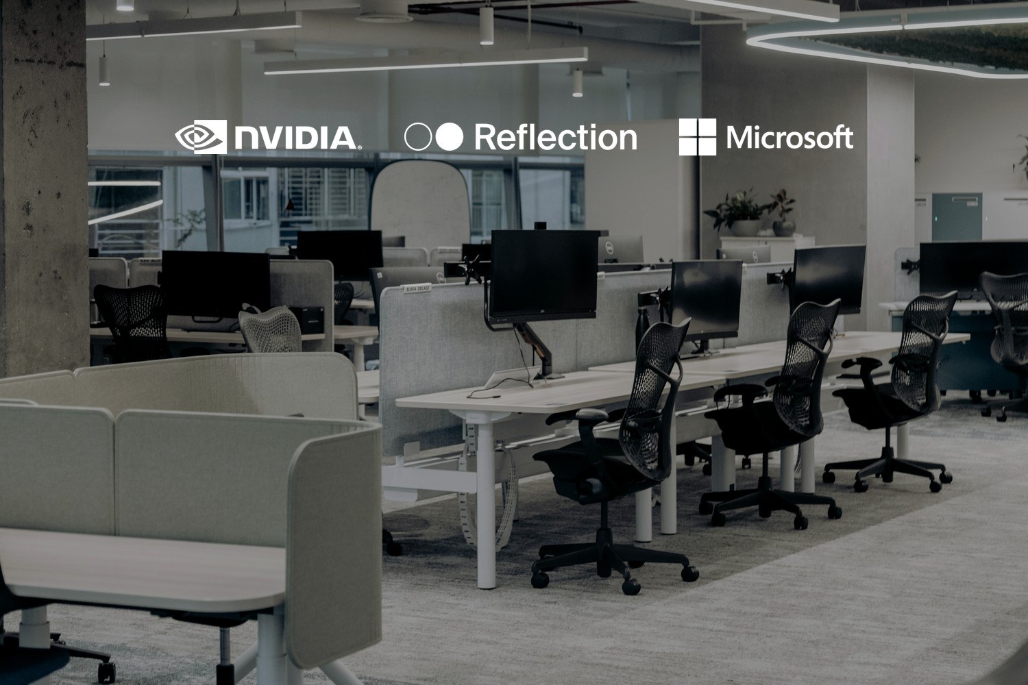 Et åpent kontorlandskap med tomme arbeidsplasser, skjermer og kontorstoler. Med logoene til Nvidia og Reflection AI og Microsoft lagt på.