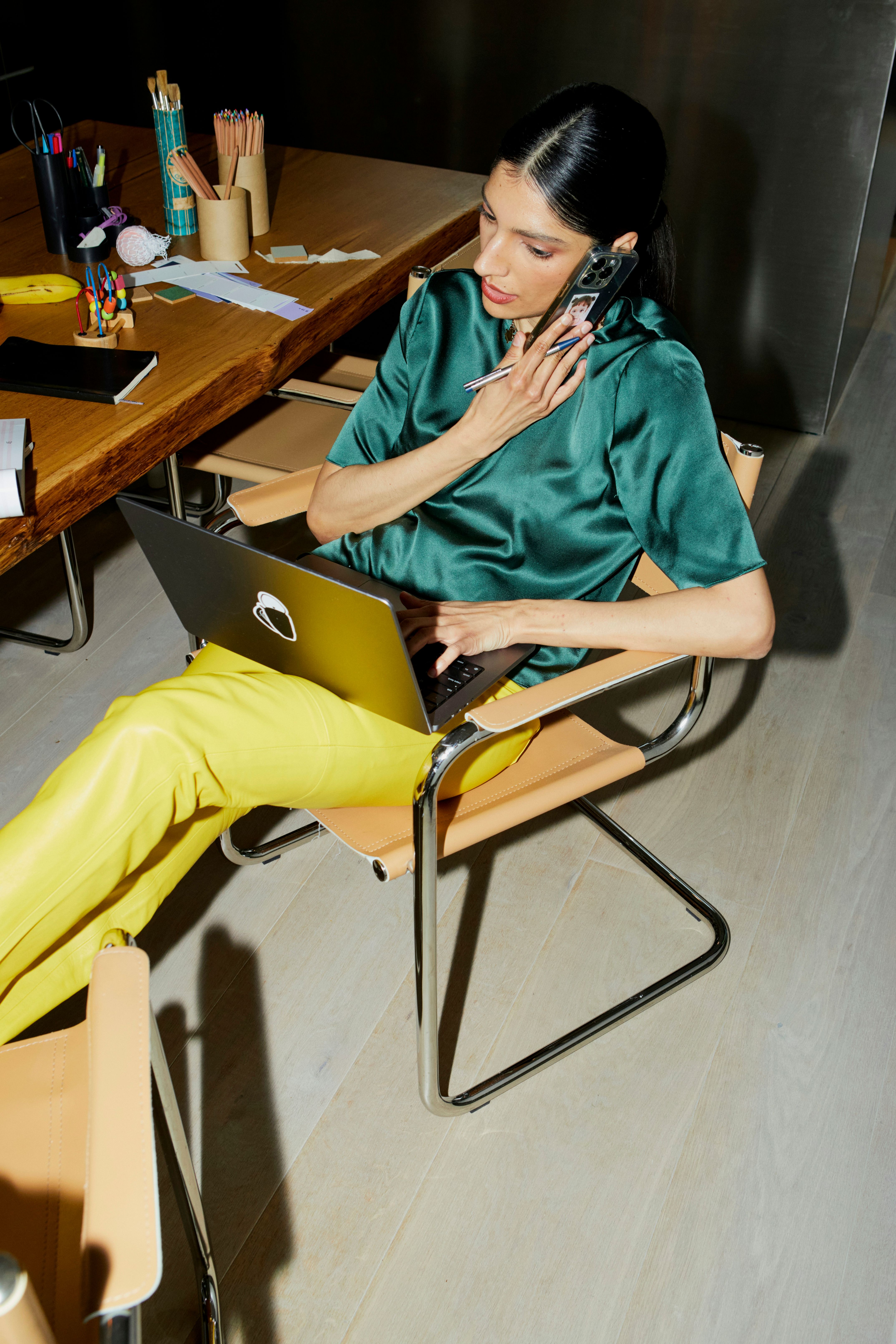 Business person talking on a smartphone while working on a laptop
