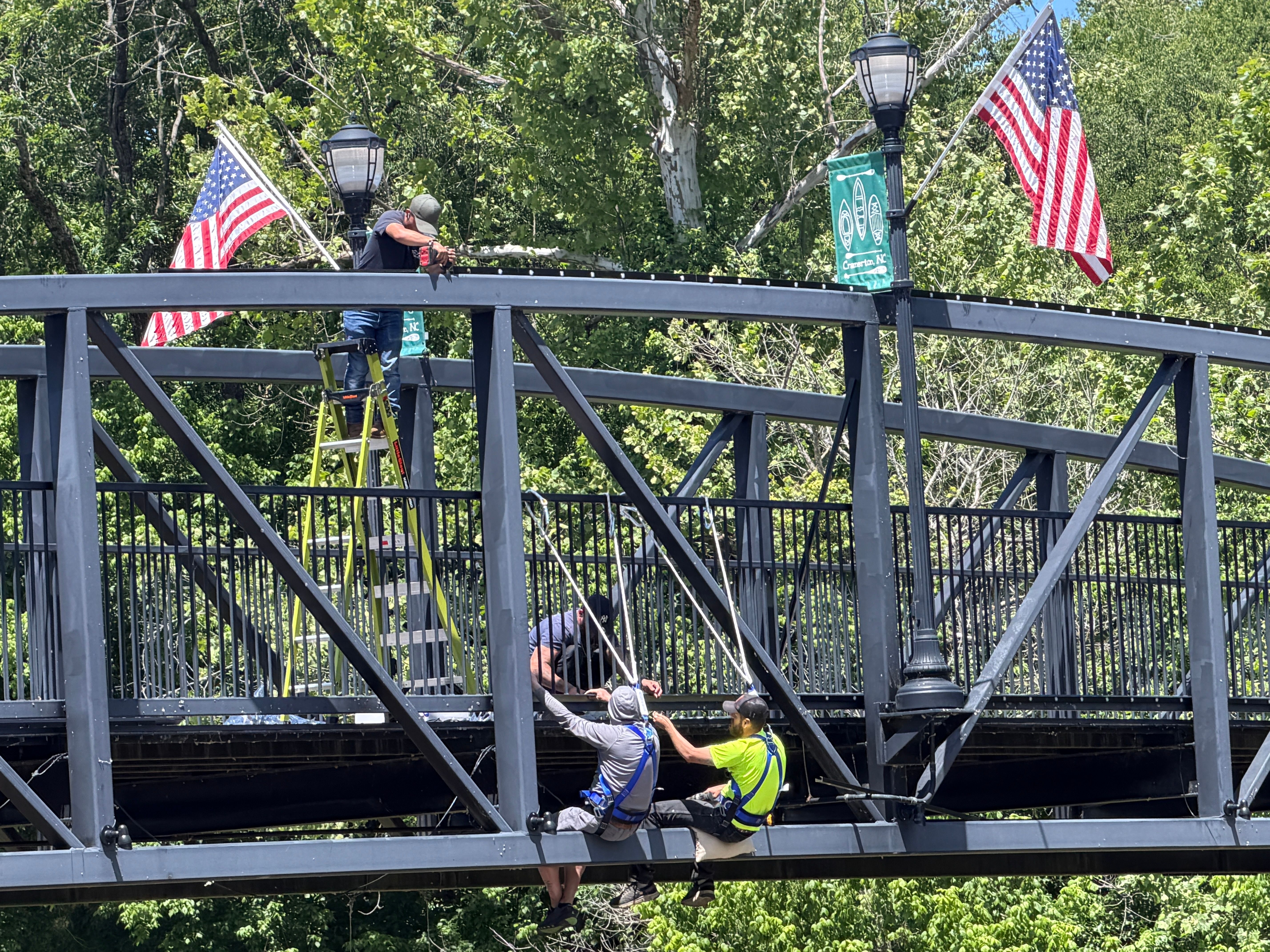 Charlotte Trimlight crew installing lighting on the Cramerton pedestrian bridge